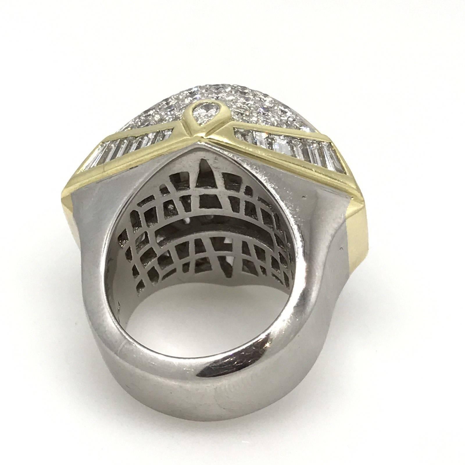 Large Diamond Dome Ring set in Platinum with 18k Yellow Gold Accents. Ring contains three rows of large Princess cut Diamonds, pave set Round Brilliants,  graduating Baguette Diamonds, and two Pear Shape Diamonds.
Total Diamond weight is 9.91