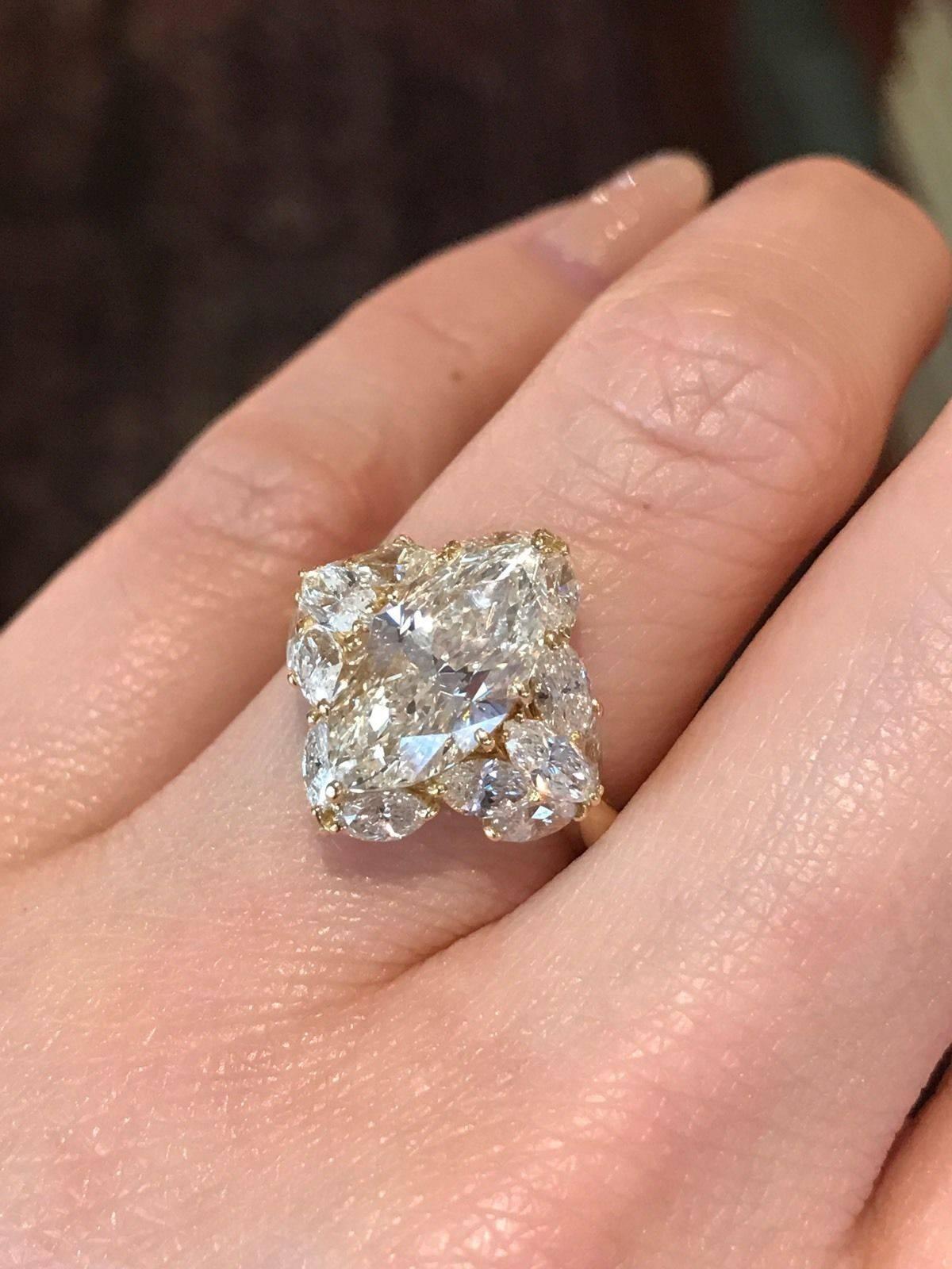 Marquise shape diamond in the center weighing 3.06 carats, surrounded by 14 Marquise Diamonds weighing total of 2.08 carats. The center diamond is SI1 clarity, Light Yellow in color. The side diamonds are VS clarity, H color. Ring weights 5.7 grams.