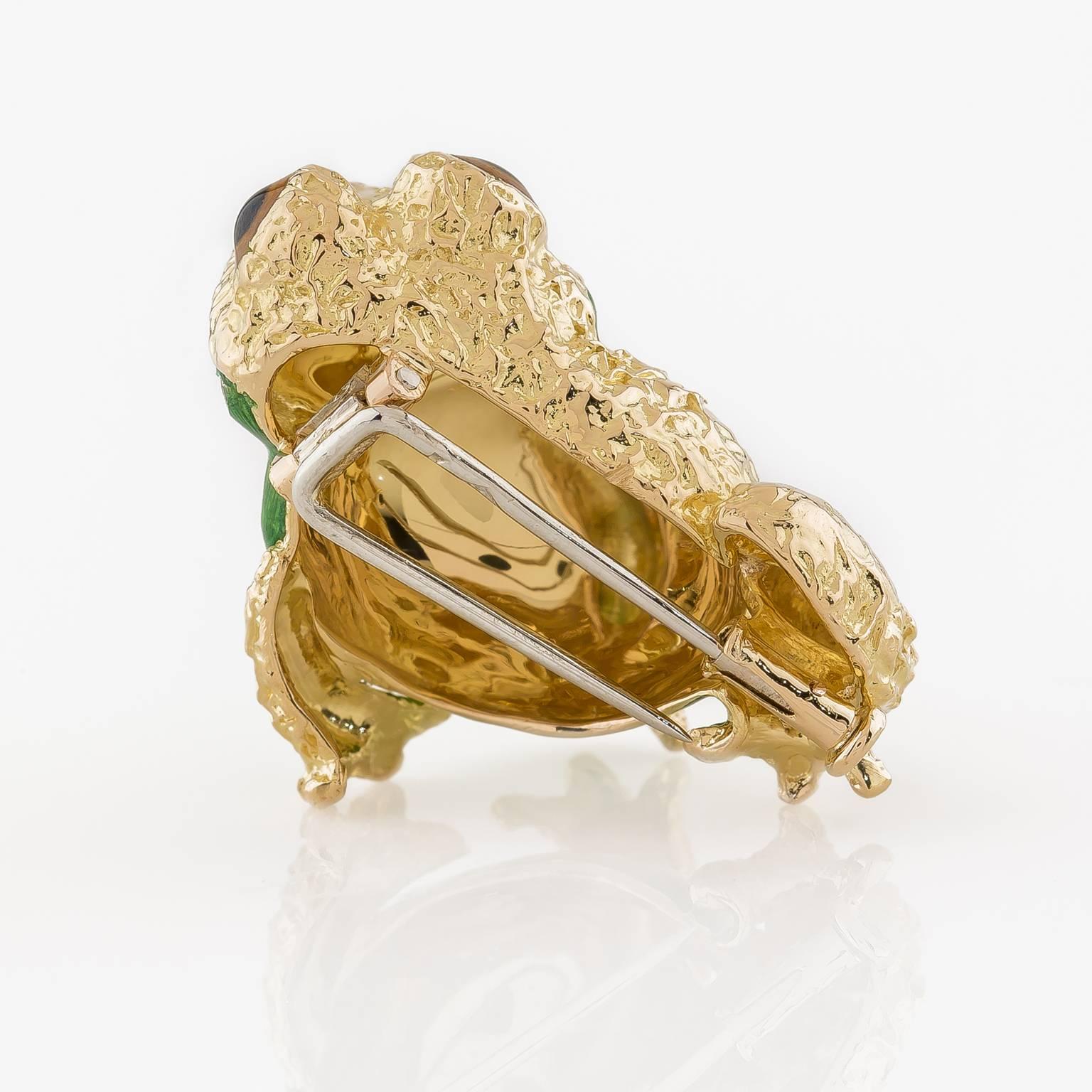 Adorable 18k yellow gold frog in a textured finish detailed with an enameled body and eyes.

1in ( 2.54cm) x .94 in (2.38cm)