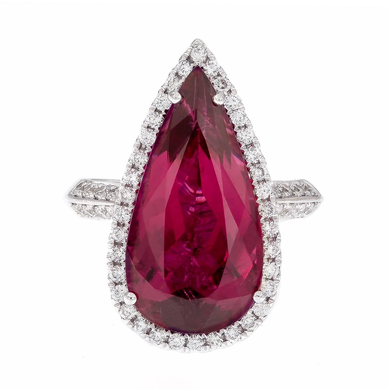 Exquisitely crafted 18k white gold ring showcases a 7.46 carat pear shape rubelite. Center stone is beautifully accented with white diamonds and perfectly balanced by diamonds running down the shank, as well as on the intricate basketwork on the