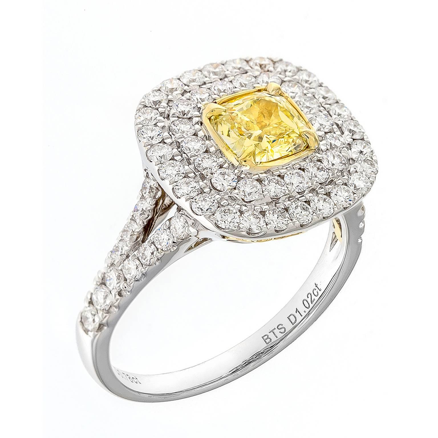 This elegant double halo ring masterfully displays the fancy intense natural yellow cushion cut diamond. The center stone is surrounded by a double halo of white diamonds, framed in 18k white and yellow gold. It is beautifully balanced by pave