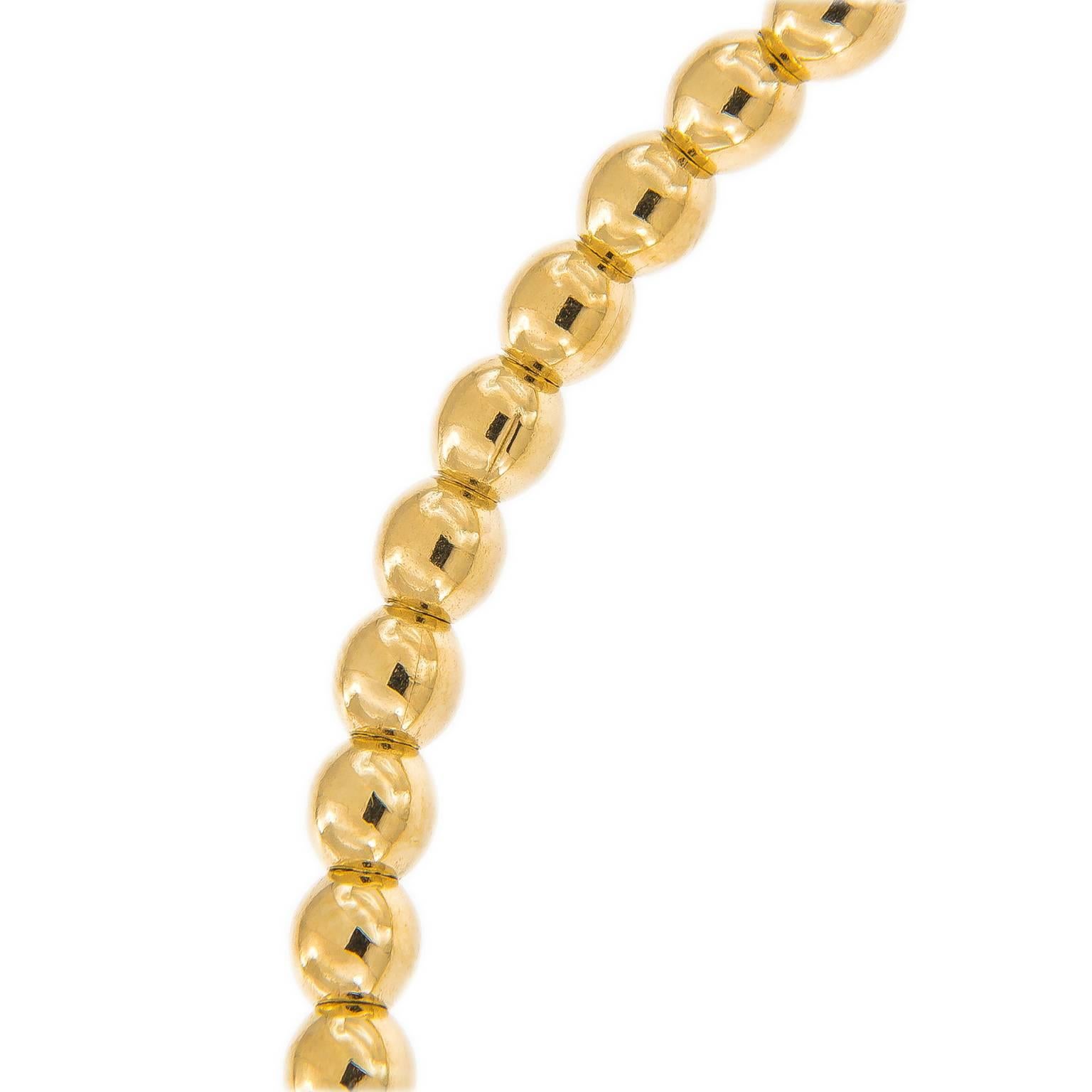 This graceful 18k yellow gold beaded bracelet, custom made in Italy for Campanelli & Pear features 20 sparkling round diamonds set in a gold bar. Bracelet is constructed with a unique stainless steel coil mechanism that allows the bracelet to