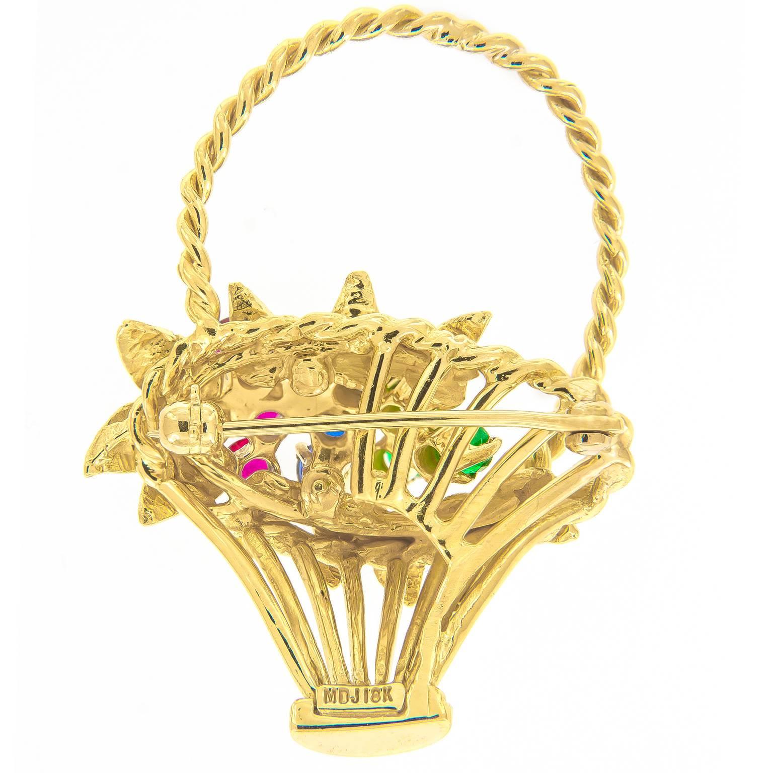 This pretty vintage flower basket brooch is exceptionally executed in 18k yellow gold and features flowers compromised of rubies, blue sapphires and emeralds.