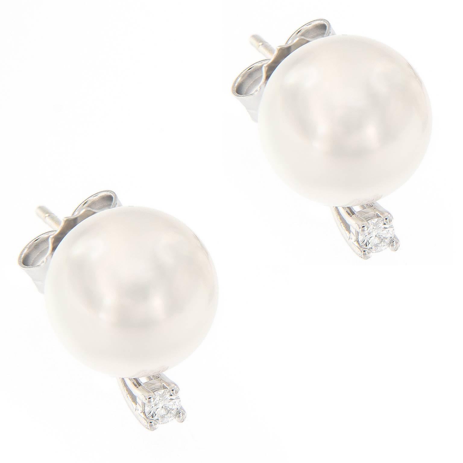 A fashion classic. A pair of approximately 10mm cultured South Sea pearls accented with a prong set diamond in 18k white gold.

Diamonds 0.10 cttw