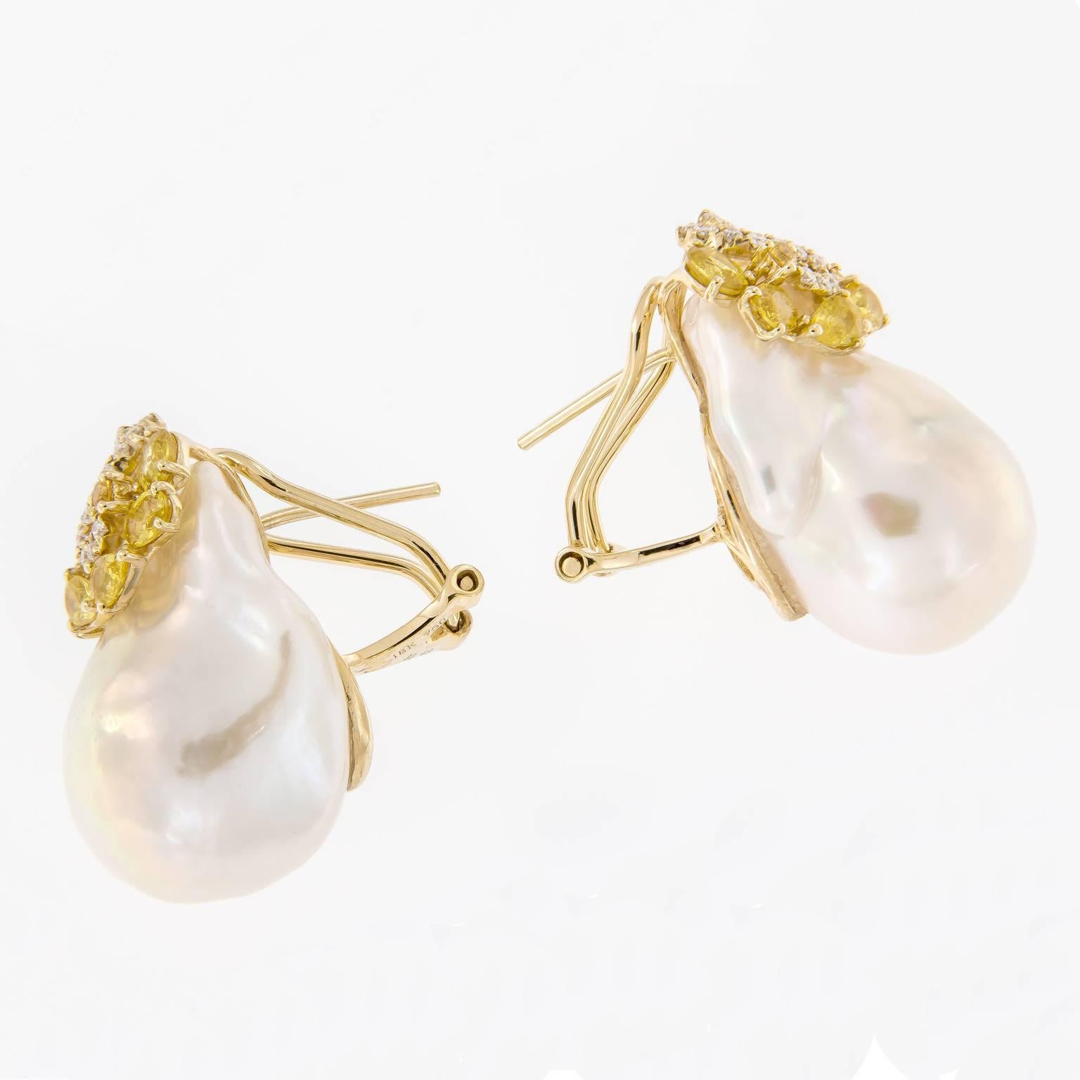 Outstanding large fresh water baroque pearls accented with a cluster of yellow sapphires and a swirl of diamonds. Earrings crafted in 18k yellow gold with omega backs. 1.25 in Long.
 
Yellow Sapphire 2.59 cttw
Diamonds 0.36 cttw