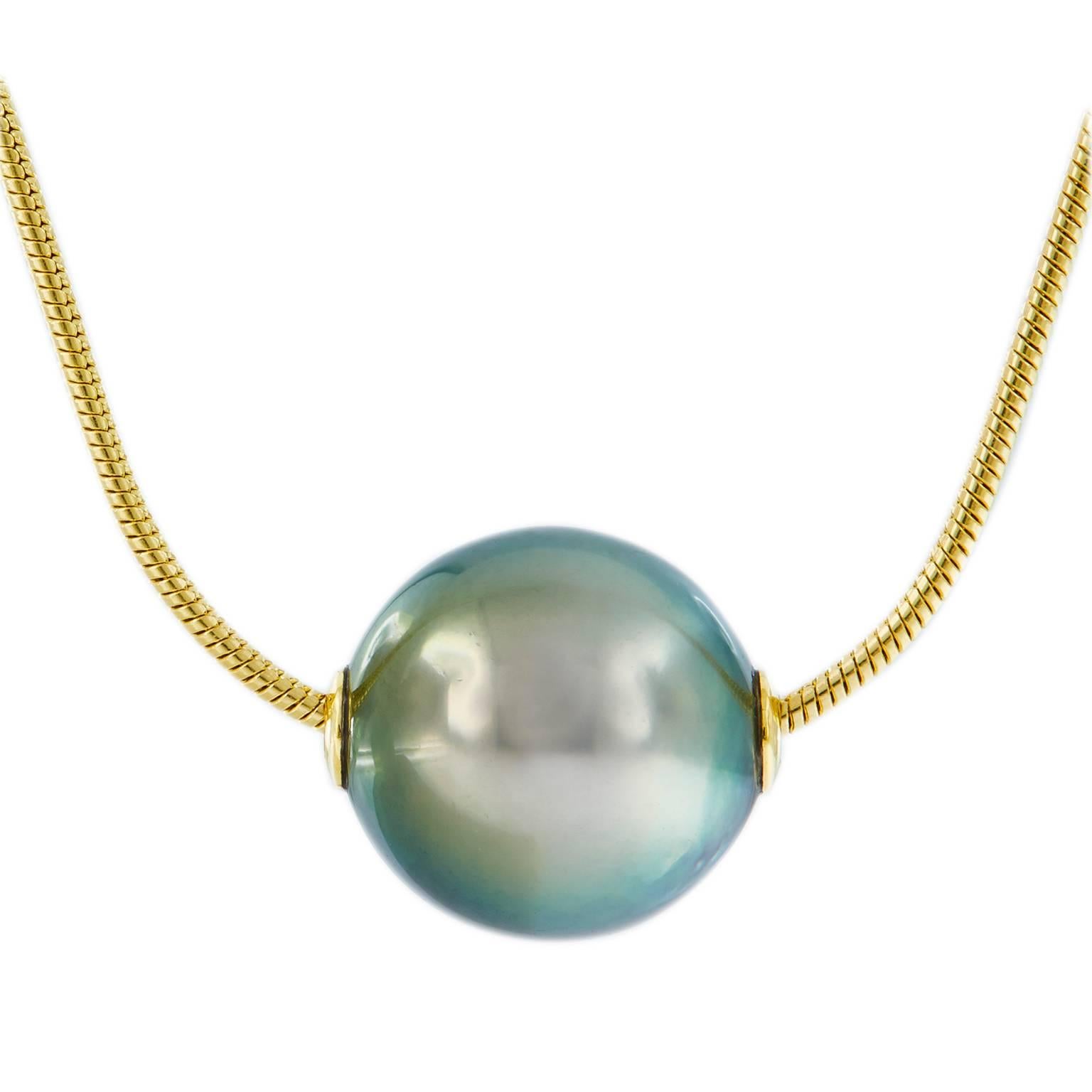 This beautiful Tahitian 10 mm pearl is given center stage in this simple yet elegant necklace. Dark gray pearl shimmers hints of pistachio and aubergine. Pearl is on a 18 in long 18k yellow gold snake chain. Weighs 5.1 grams.