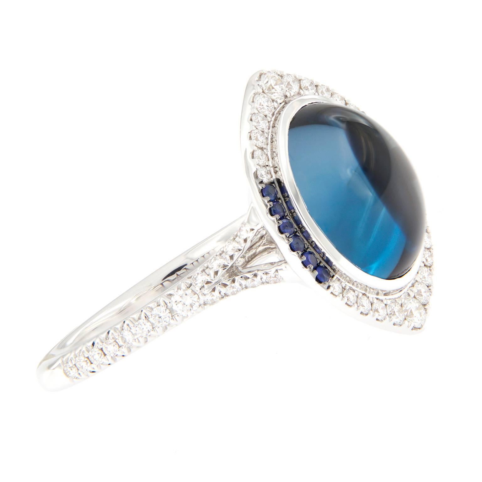 Danhier creation from the Candide Eye Collection. This beautifully crafted ring centers around a 6.14 carat cabochon London blue topaz accented with a halo design of white diamonds and blue sapphires. US ring size 6.75
Weighs 7.9 grams.

Topaz 6.14