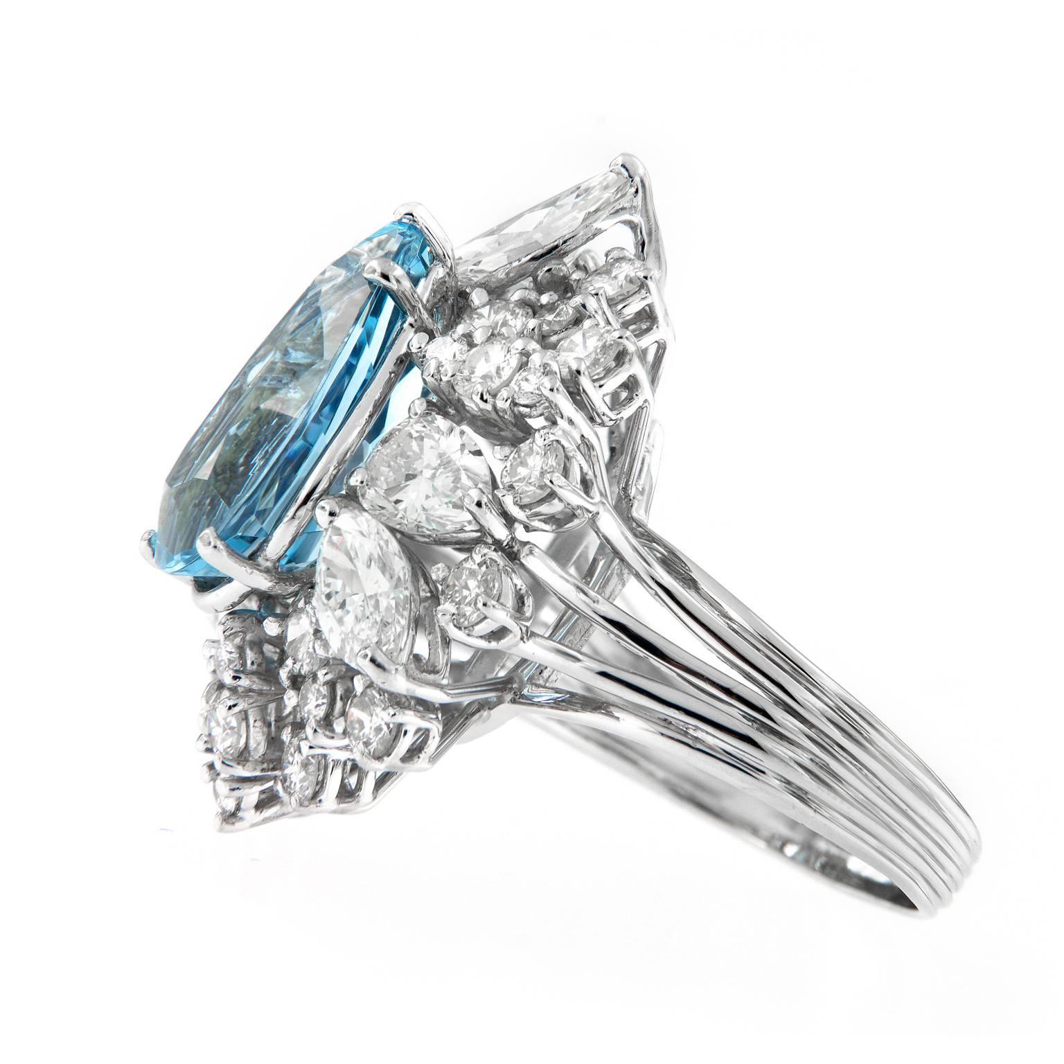 Be prepared for compliments with this exceptional cocktail Ring. Ring centers around a stunning 5.27 carat pear shaped aquamarine of intense sky blue color, the quintessential color of the finest aquamarine. Auqamarine is surrounded by a cluster of