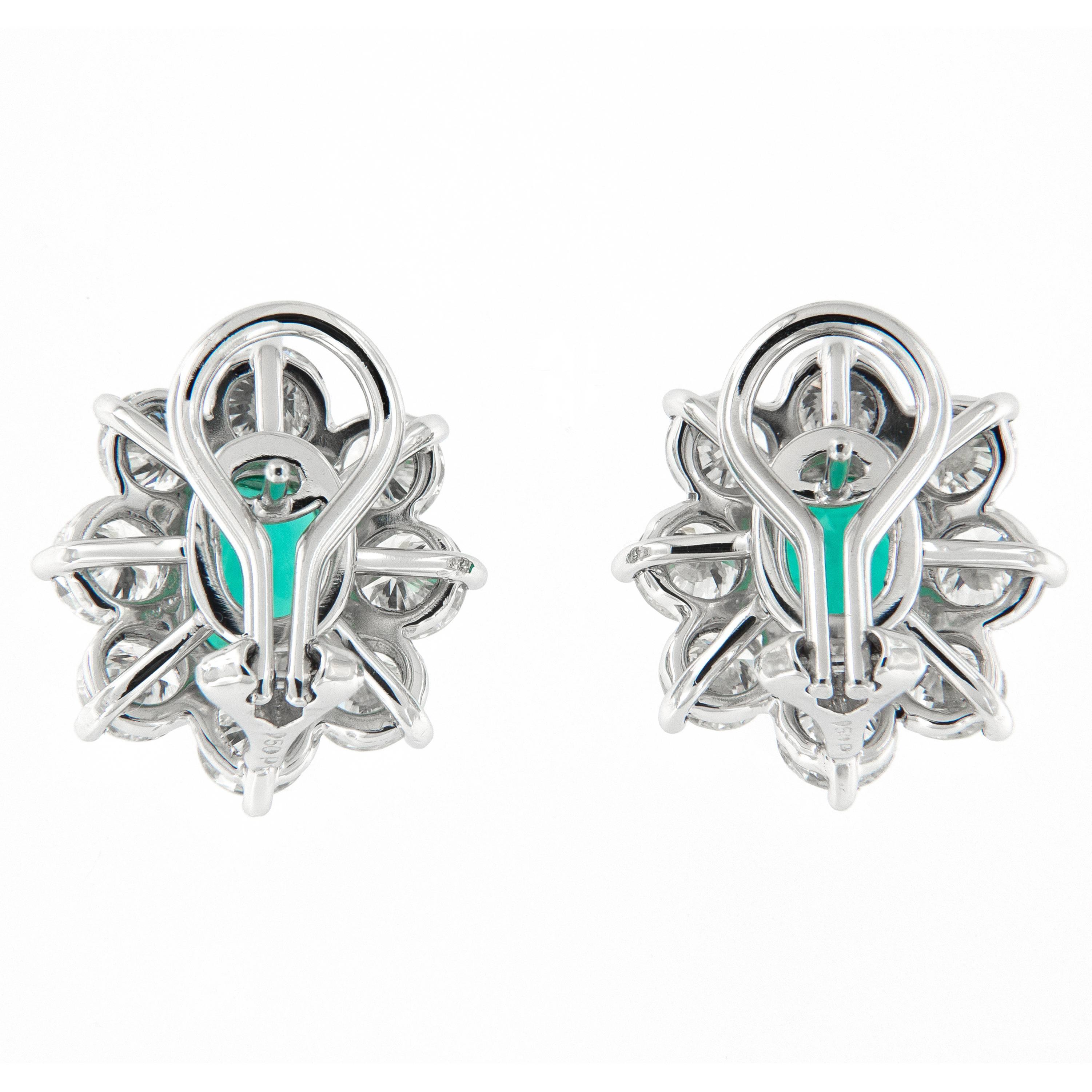 Classic cluster stud earrings crafted in platinum. Earrings center around oval rich green emeralds accented each with eight near colorless round brilliant cut diamonds. These earrings have a post and french clip. Weigh 10.3 grams.

Emerald 2.25