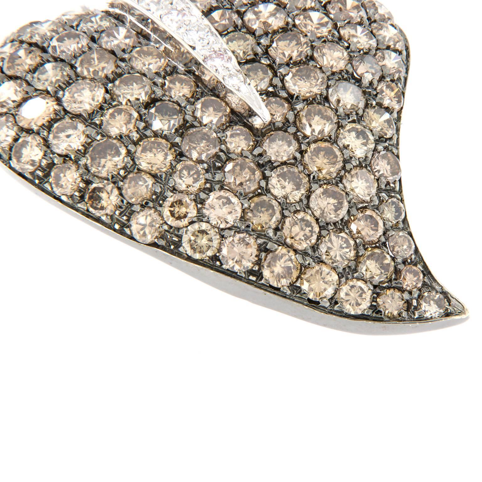 This estate stylized 18k white gold leaf brooch is pave set with 5.00 Cttw. white and chocolate diamonds. Can also be worn as a pendant & has a double prong pin for security

Diamonds 5.0 cttw est.
27 x 37mm