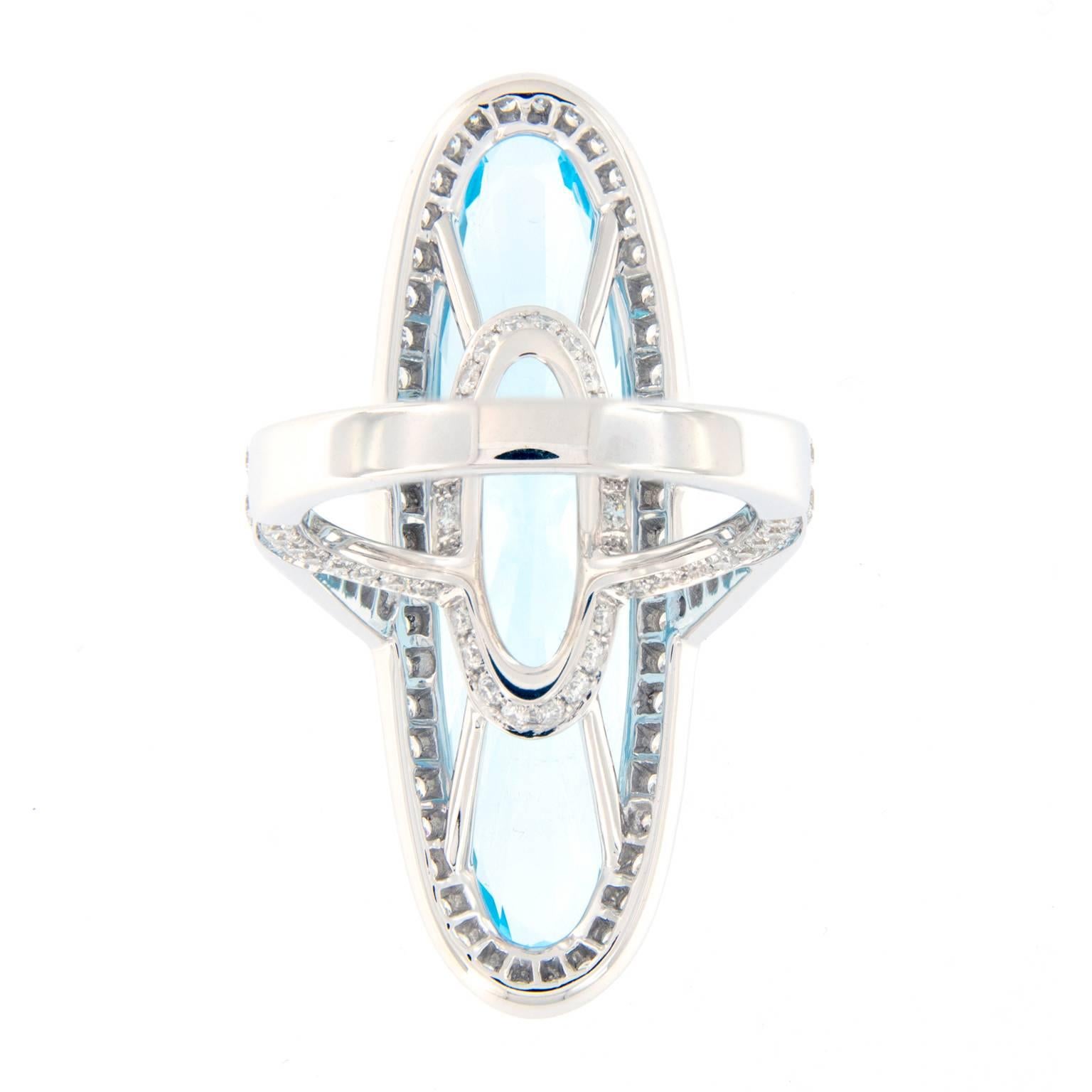 Dramatic and stunning cocktail ring showcases a long beautiful topaz with a diamond halo and diamonds set in a split shank. Ring crafted in 18k white gold. Ring size 6.5. Weighs 13 grams

Topaz 17.55 ct.
Diamond 1.37 ctw