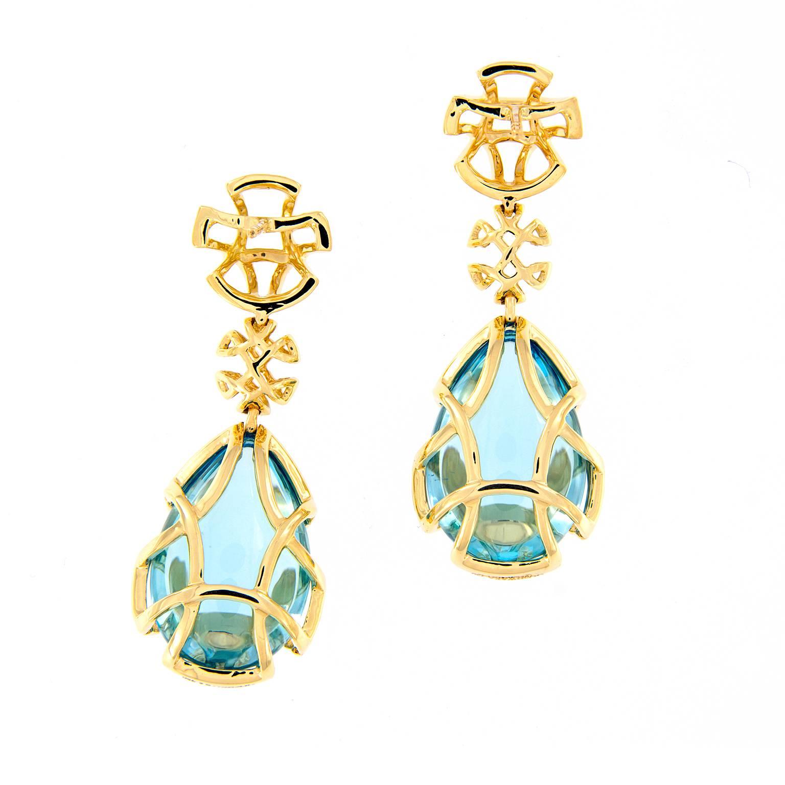 These blue topaz teardrops drop from double 18k yellow gold discs and are covered in a gold cage design. From the Freedom Collection designed by Goshwara. Weighs 20.8 grams. Marked Goshwara.

Blue Topaz 18.08 cttw