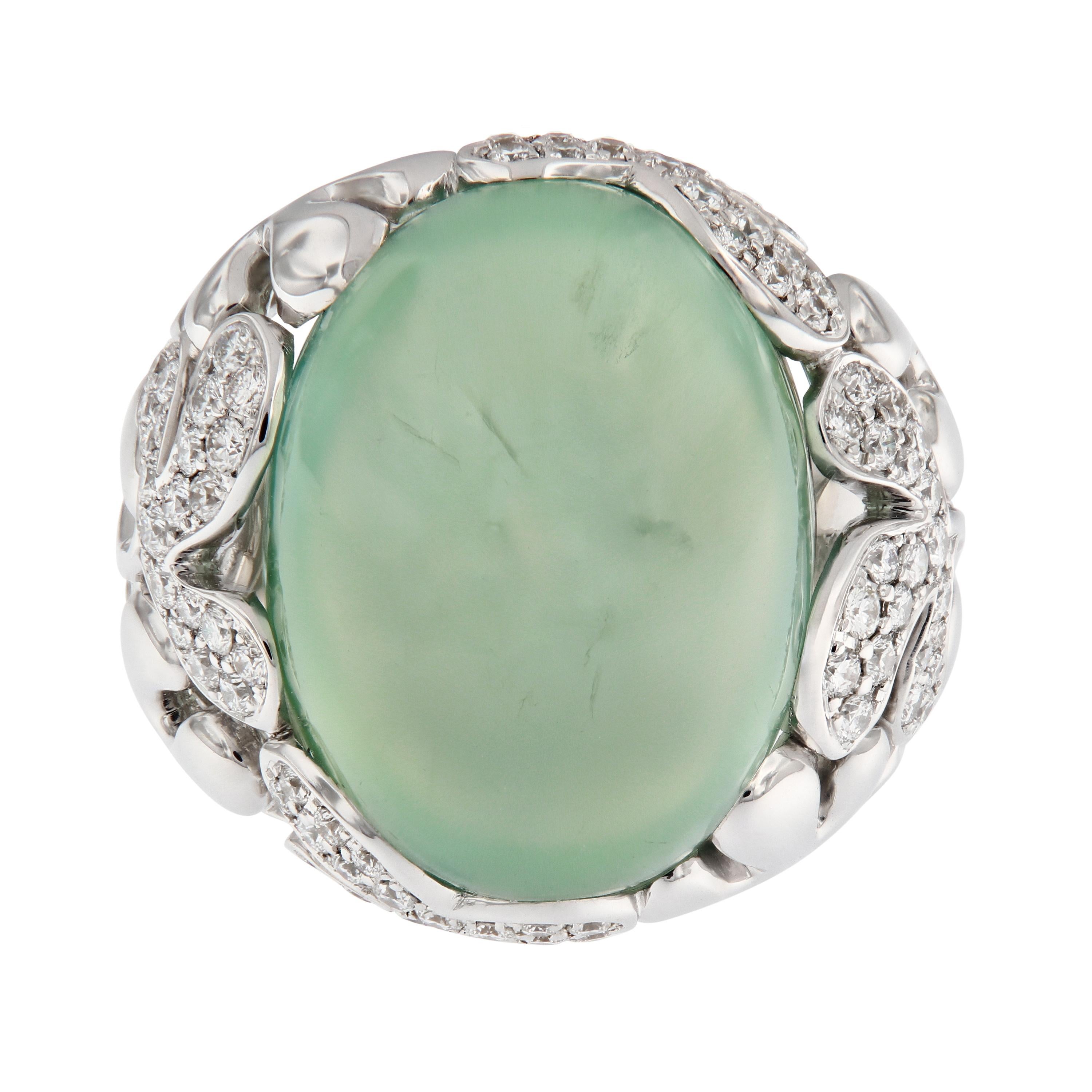 A whimsical floral design graces the setting of this large stunning cabochon-cut prehnite. The ring is beautifully crafted in 18k white gold and accented with diamonds. The combination of stone and design is feminine and presents a substantial but