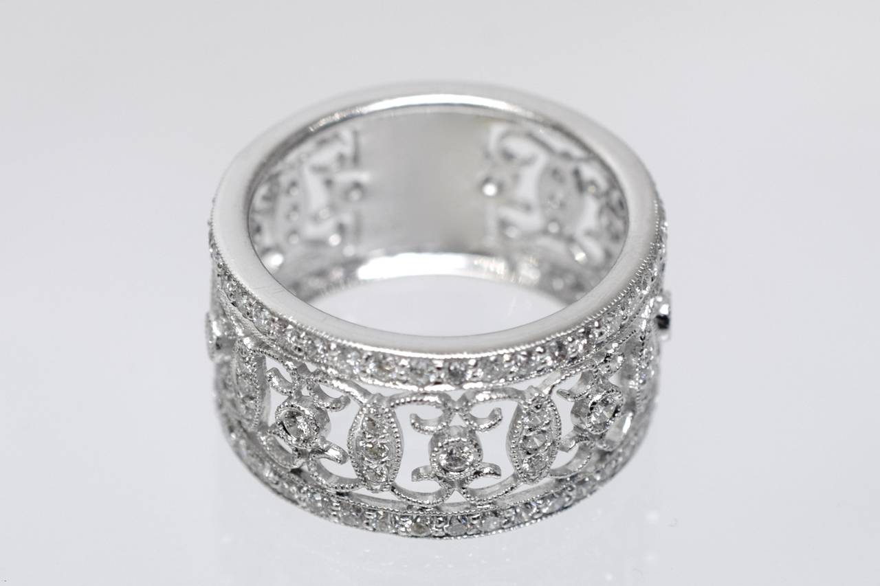 Délicat motif de dentelle symétrique avec bande à finition filigrane. 
114 diamants ronds et brillants sertis en or blanc 18k. 
Le poids total estimé du diamant est de 1::15 carats Couleur G & Clarté VS
La largeur de la bague est de 11 mm
La taille