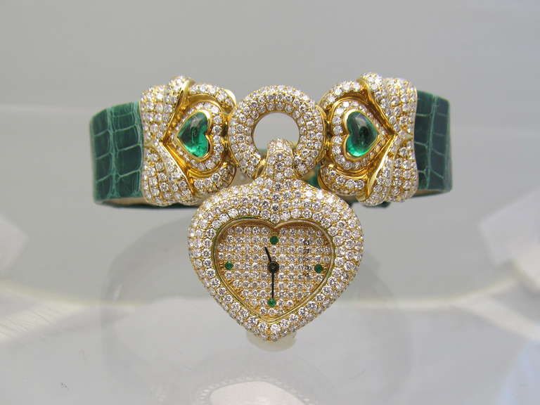 Graff Lady's 18K Yellow Gold, Diamond and Emerald Heart-Shaped Wristwatch

The Dial, Bezel, Top Of The Bracelet And Buckle Containing Round Brilliant Cut Diamonds Weighing Approximately 5.0 Carats Total. Two Heart-Shape Cabochon Cut Emeralds, Pave