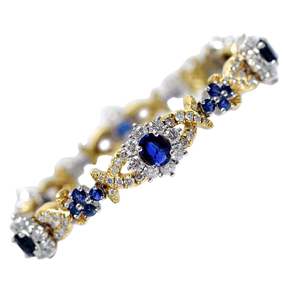 Beautiful floral motif  sapphire and diamond bracelet.
Six vibrant blue color oval shape sapphires surrounded with diamonds set in platinum, both sides are diamond encrusted yellow gold X-s. The links are connected with a smaller link, designed as a