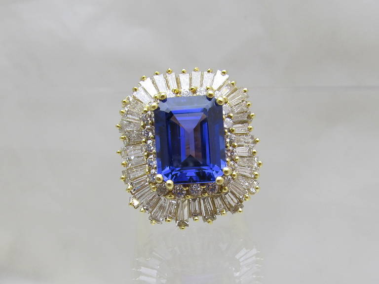 Impressive l 10.93 carat emerald shape Tanzanite set in 18k gold, surrounded with 20 brilliant shape diamonds 0.80 carats and 36 emerald shape diamonds 5.20 carats  in a wave design.
Measurements of the top of the ring is 1x1