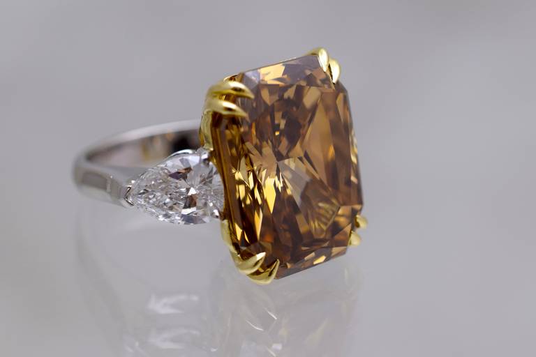 Exquisite!
Impressive cognac color diamond solitaire
Center diamond is 20.51 carat G.I.A. certified rectangular cut cornered modified brilliant flanked with 2 pear shape diamonds.
Center diamond is:
Size:  20.51 carats
Color:   Natural Fancy