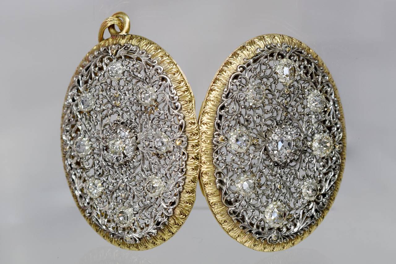 Mario Buccellati!  
This is an exquisite openwork lace workmanship double sided diamond locket/pendant  by the Italian jewelry firm Mario Buccellati with
40 diamonds  set in white gold bordered by 18k yellow gold.
 Total diamond approximate