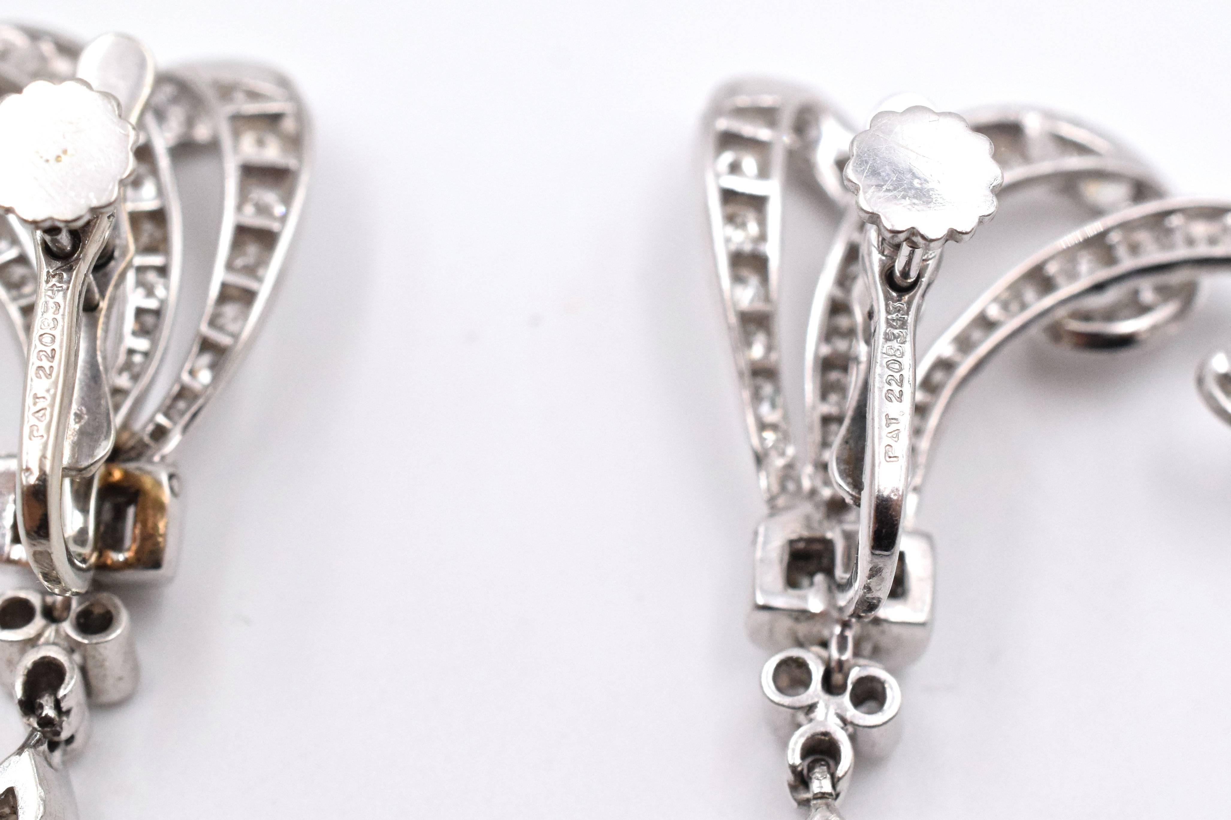 A Pair of Platinum and Diamond Pendant Ear-clips, in a stylized plume motif with hinged drops, containing two antique marquise cut diamonds weighing approximately 2 carats total, six baguette cut diamonds weighing approximately 0.30ct total weight