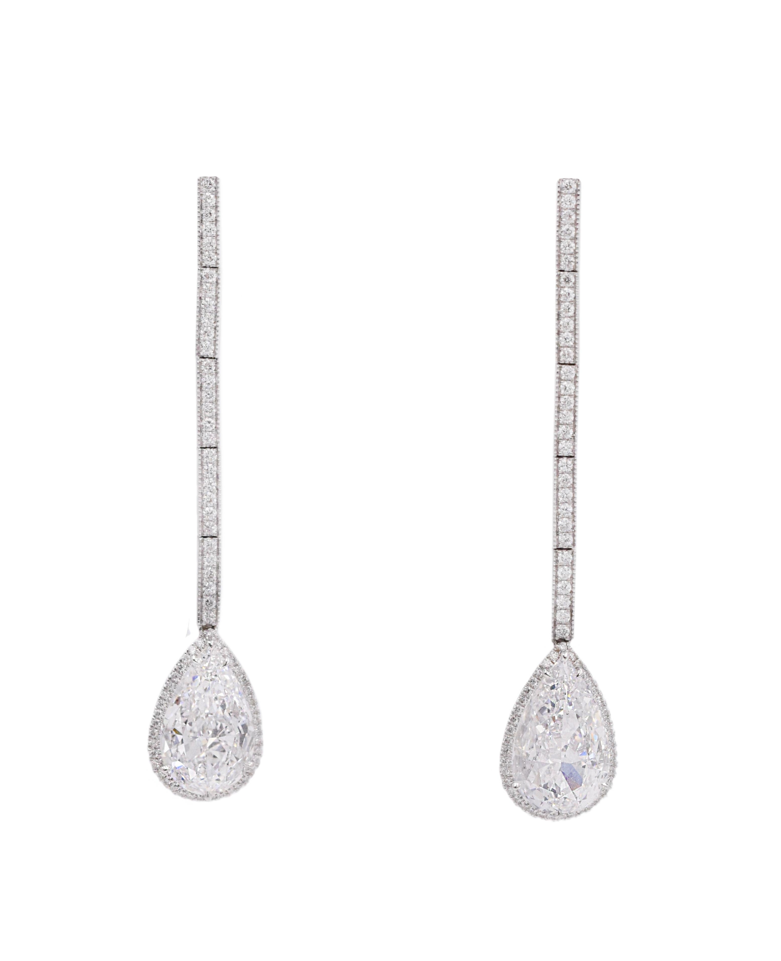 Pear shape drop earrings with the halo. Made in platinum and 18k white gold, set with 142 round brilliant cut diamonds, total weight 0.65 carats color: E-F, clarity: VS, with suspended with two GIA certified diamonds 3.02carat and 3.03 carat 
Both