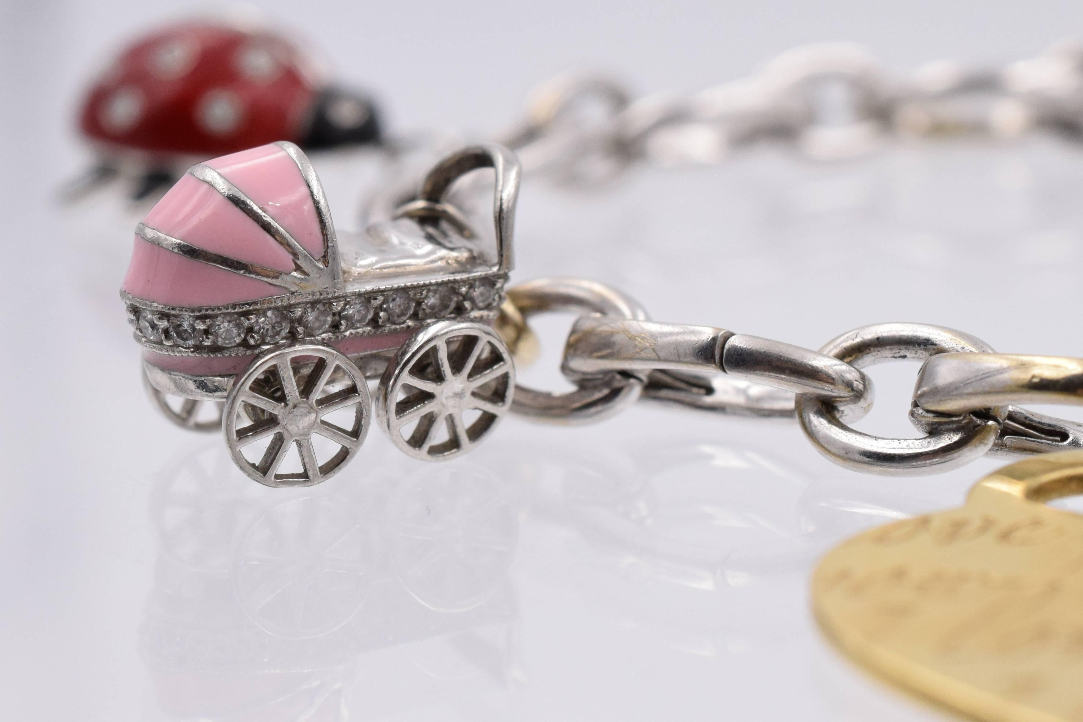 Tiffany & Co   wimsical 18k white gold charm bracelet with 5 charms
Lady bug is  platinum & red enamel with diamonds
Baby carriage platinum &  pink enamel with diamonds
Ginger bread man is silver with teal enamel
 Heart is 18k gold
Length of