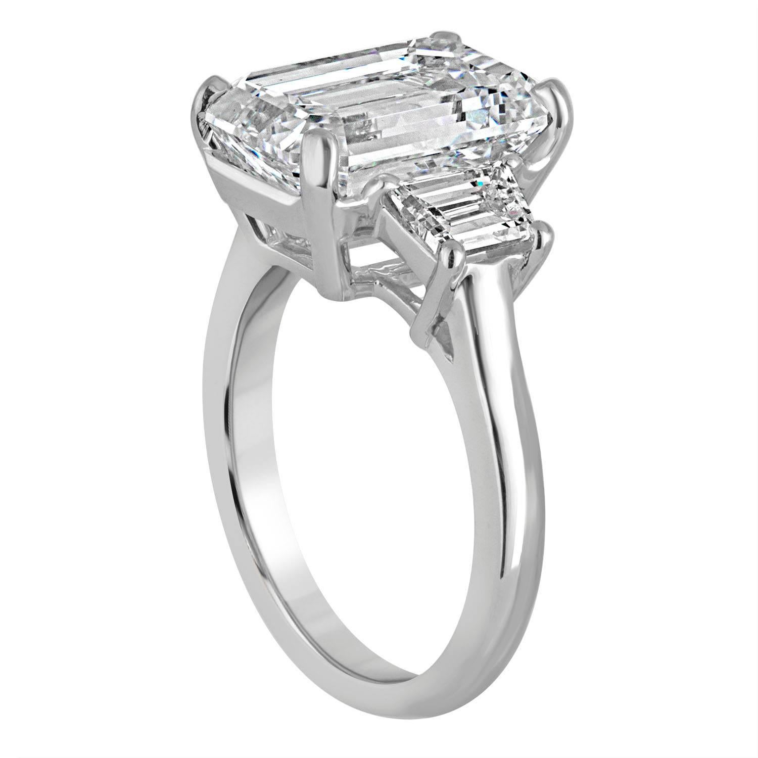 Classic Three stone ring. A 6.19 Carat Emerald Cut Diamond in the Center, is GIA certified as G in Color and VVS2 in Clarity. This Emerald Cut is set in Platinum Hand Made mounting with Two Trapezoids, 1.10 CT TWT.