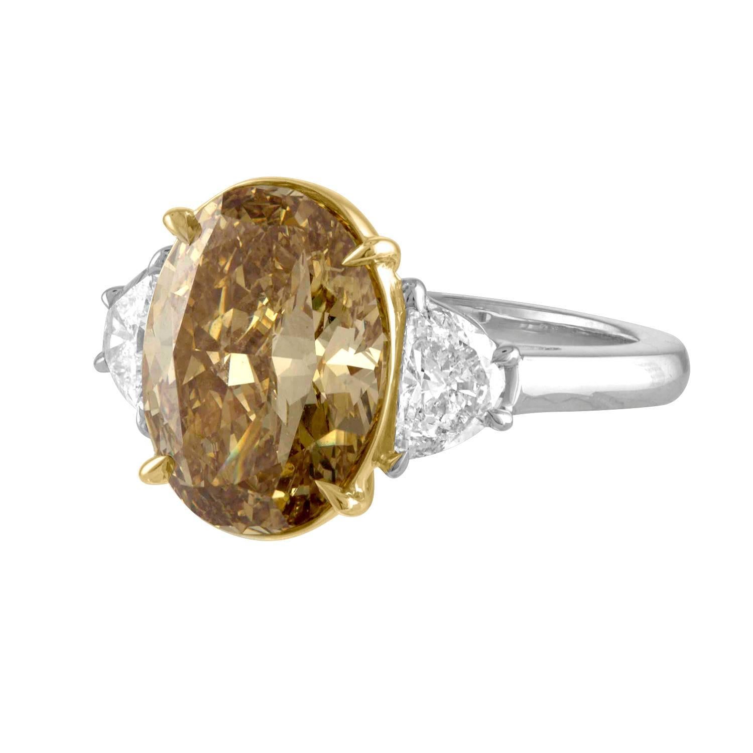 Brilliant 5.05 Carat GIA Oval Diamond Fancy Deep Brownish Yellow VS1 is set in Two Tone Mounting. 18 Karat Yellow Gold with Platinum.
On the Two Sides there are Two Half Moons 0.84 Carat Total Weights.
The GIA Certificate number is 2185708269.