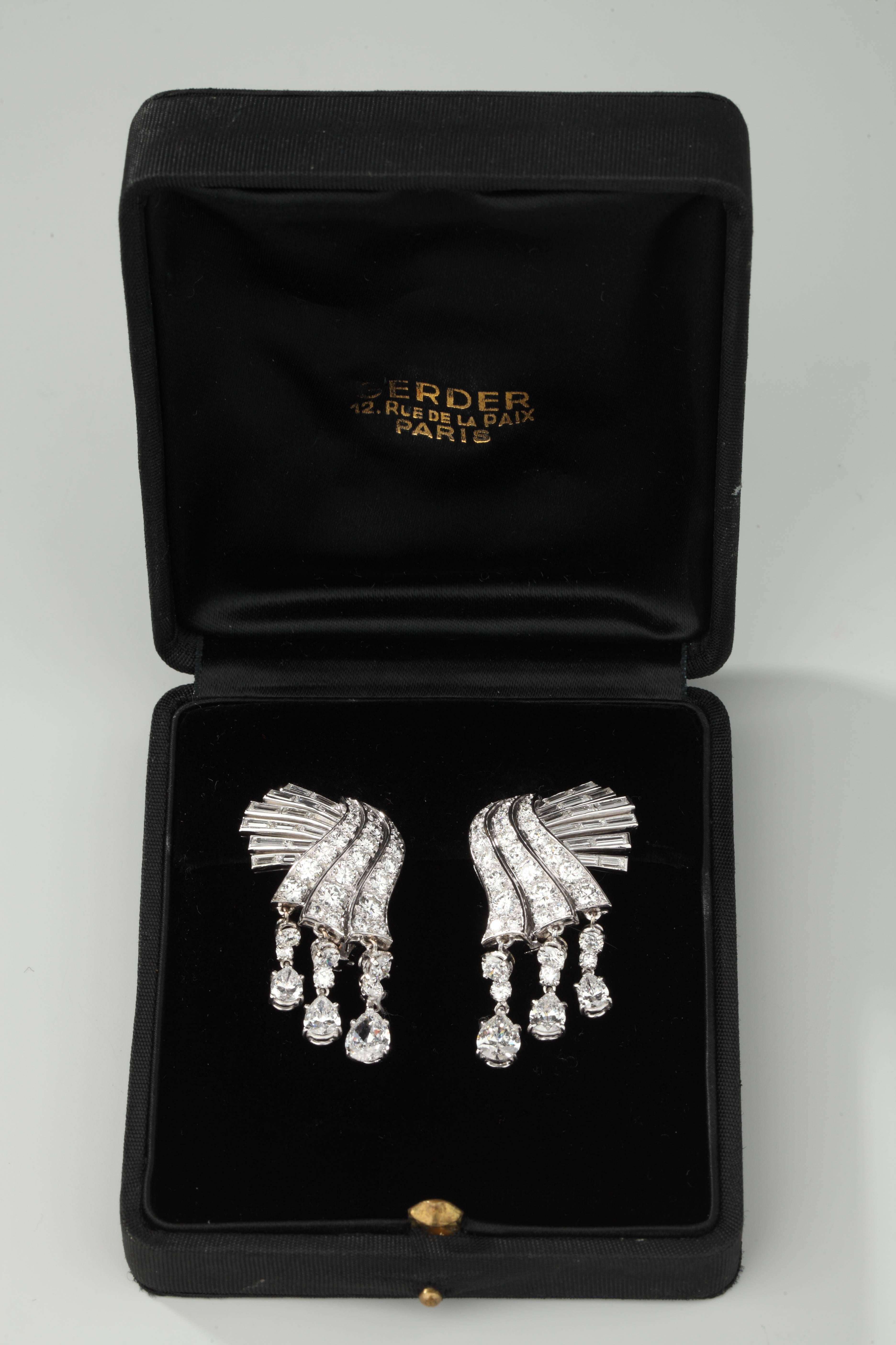Pair of platinum ear clips composed of a motive of three lines of fall of brillant cut diamonds ornated with five lines of baguette cut diamonds and three pendant lines of diamonds finished by pear cut diamonds.
Weight of diamonds is around of 12