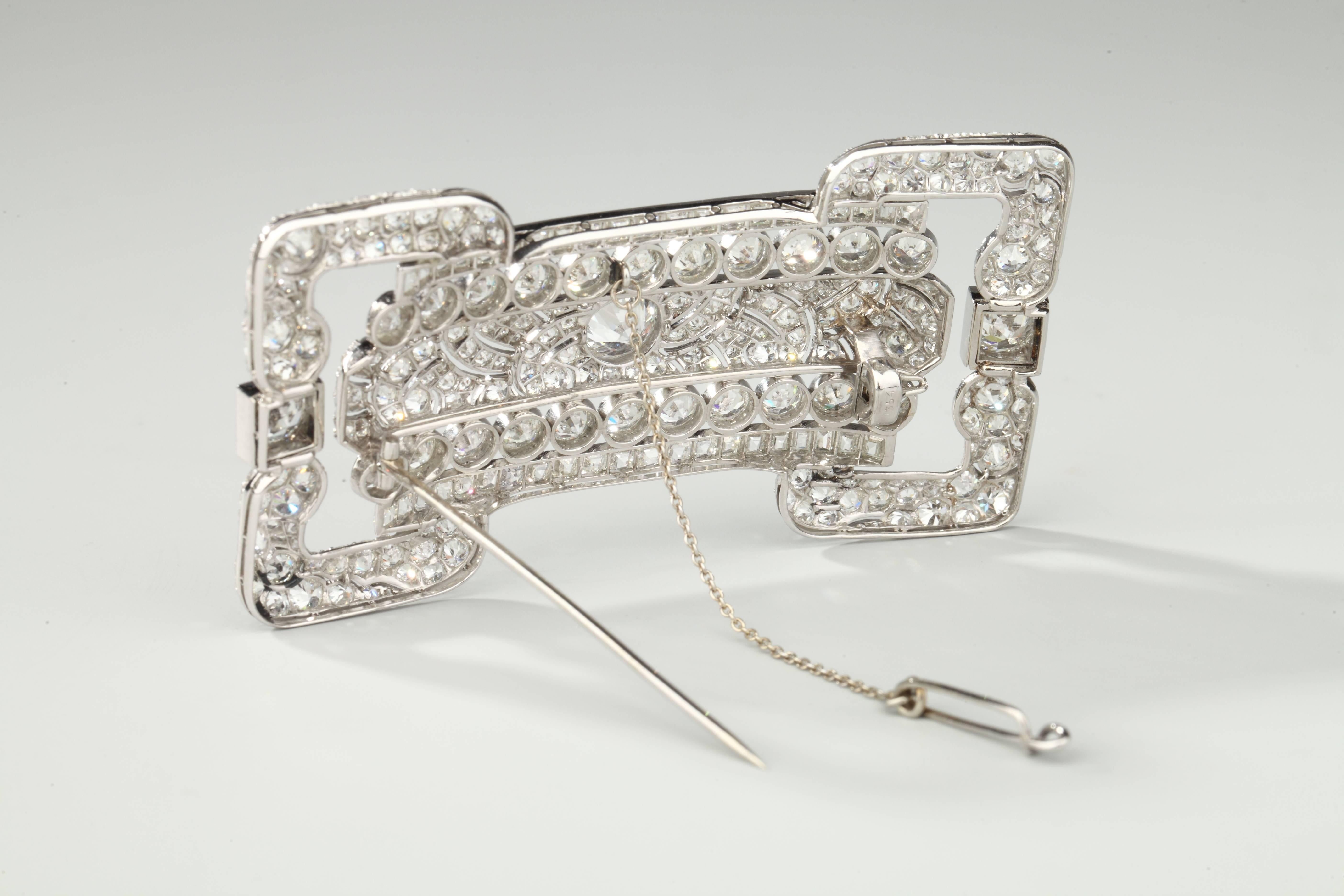 Large brooch in platinum designed as belt buckle set with round and square cut diamonds, the center one around 1.25 ct.
Total weight of diamonds around 22 carats.
The pin is in 18k gold.