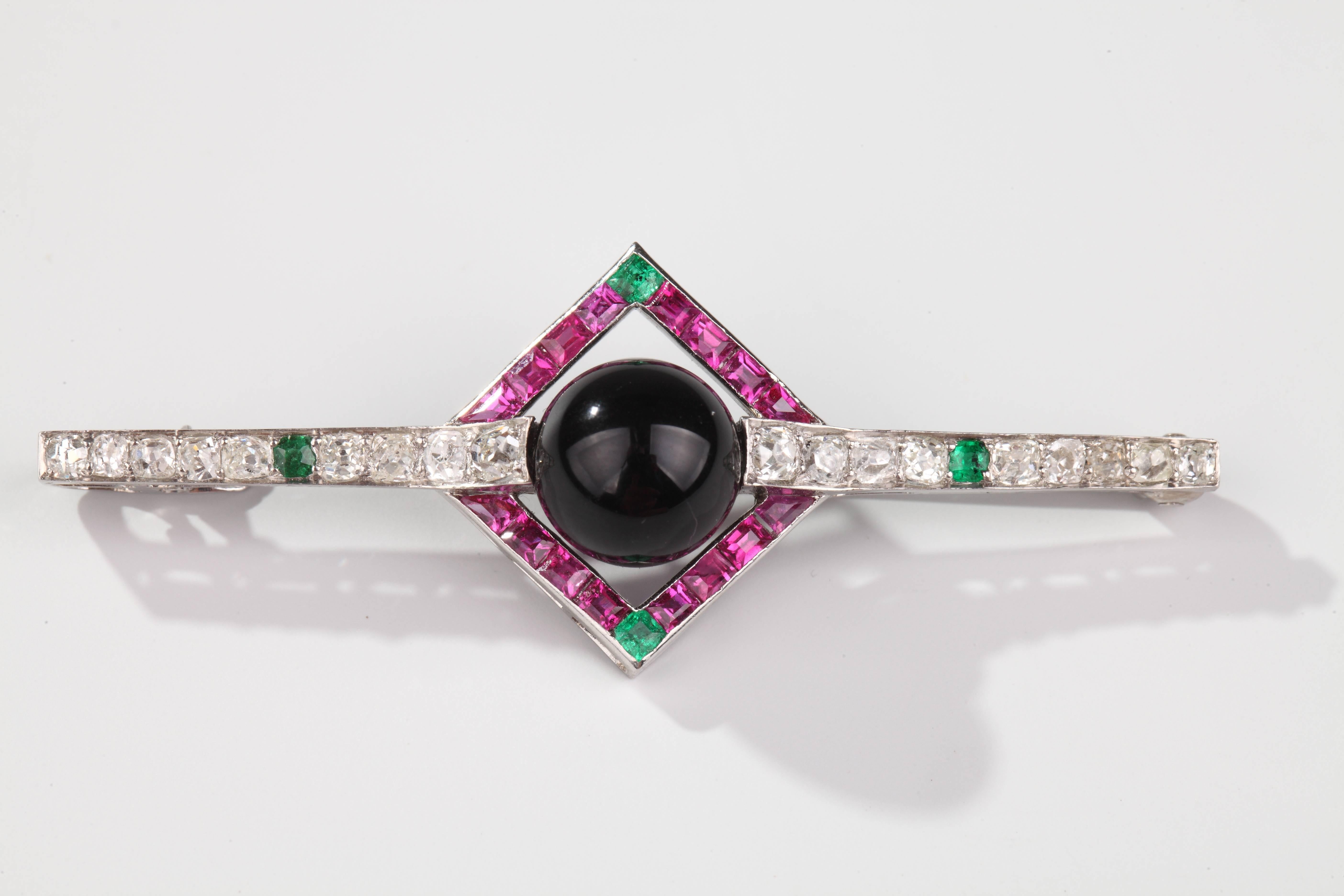 Nice geometrical design brooch in platinum set with old-cut diamonds, calibrated rubies and emeralds and one round ball of onyx.
Signed Lacloche Freres.
Circa 1925.

