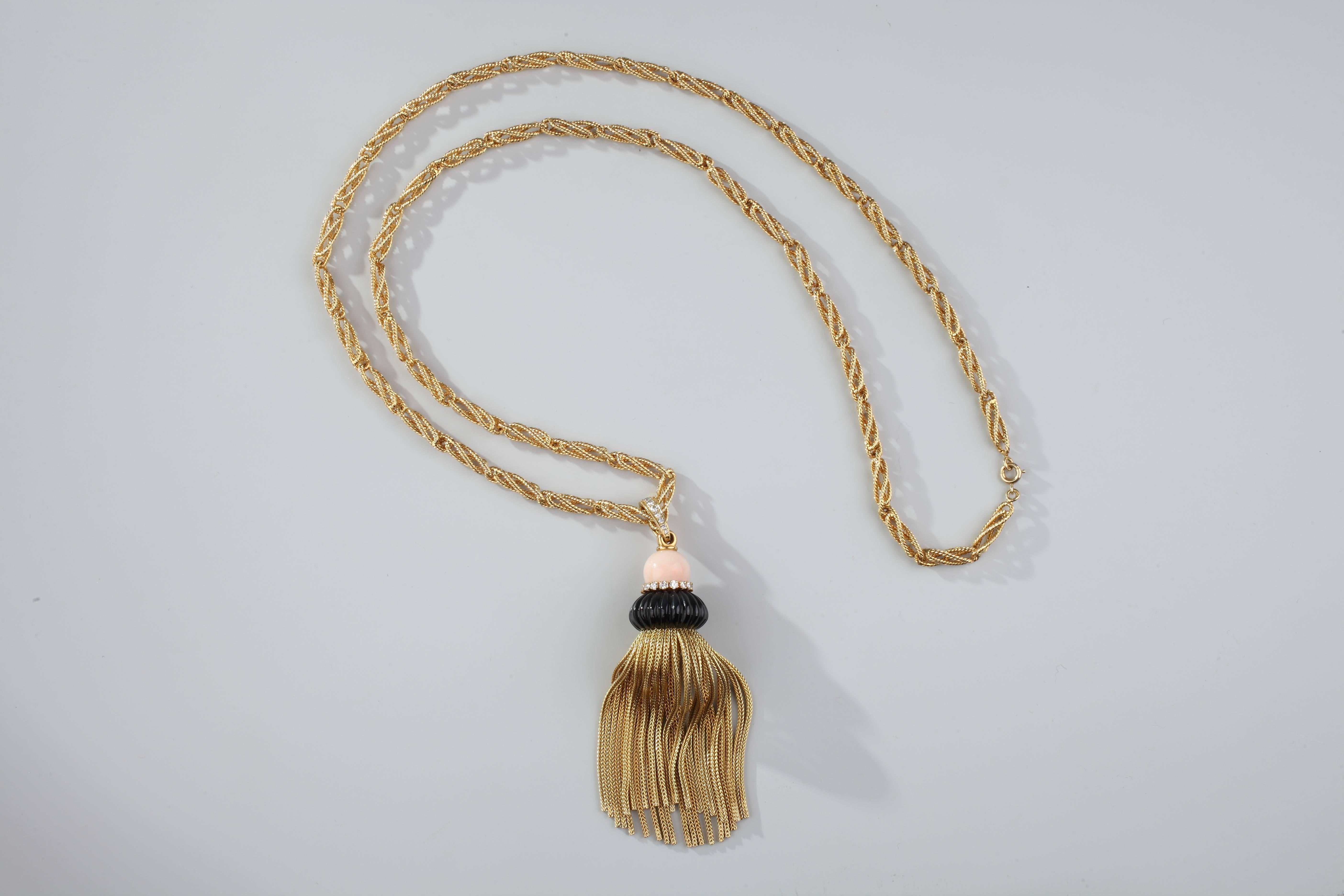 Spiral and corded elongated stick in 18k gold, holding a pompom decorated with scalloped onyx, with coral angel skin, the belt as the beliere set with brillant-cut diamonds.