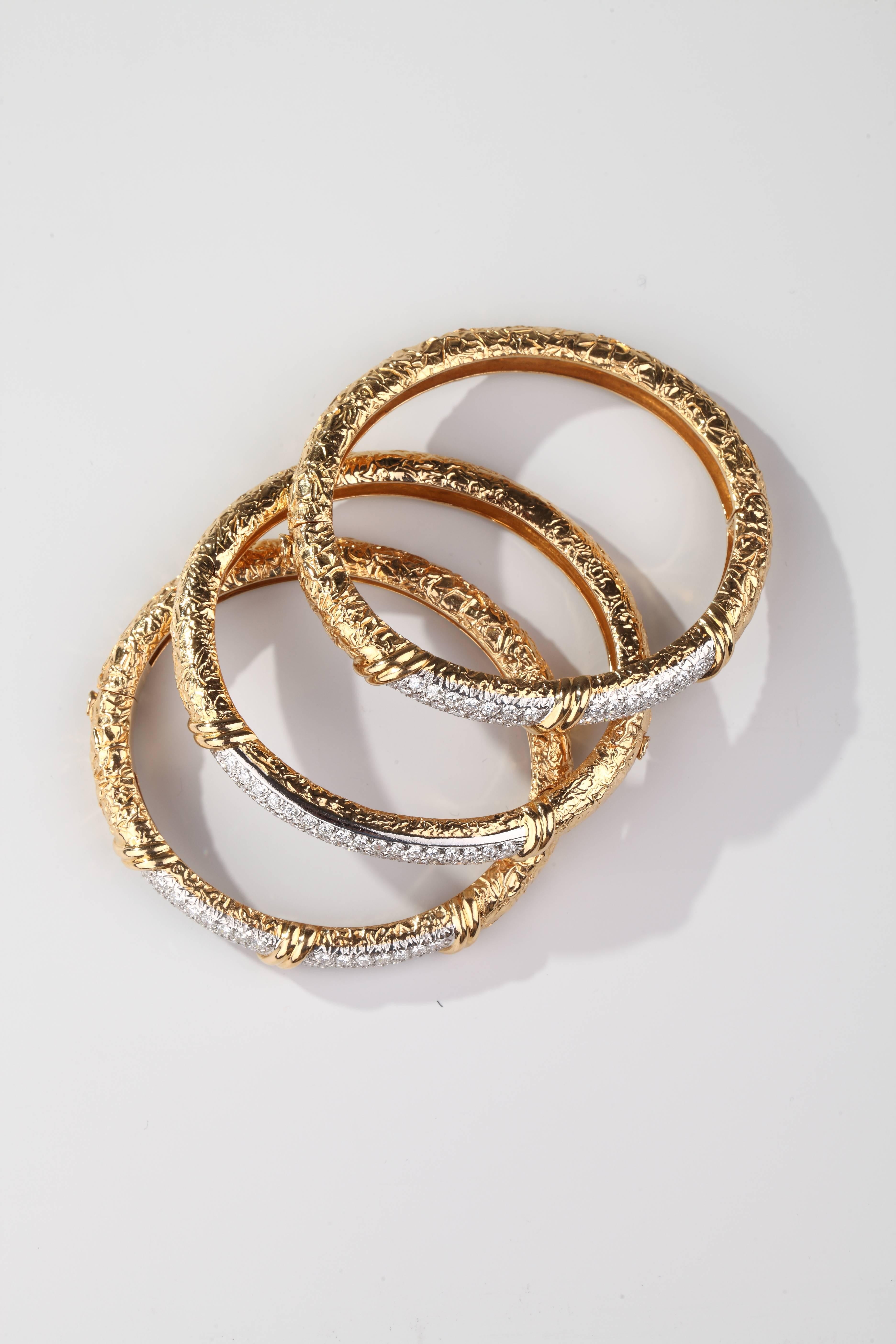 Three opening stiff bracelets in textured 18k yellow gold ornate on the top with motives set on platinum with brillant-cut diamonds. (weight around 6 ct FG VS quality on each bracelet).
Signed and numbered VCA.
French assay marks for gold and