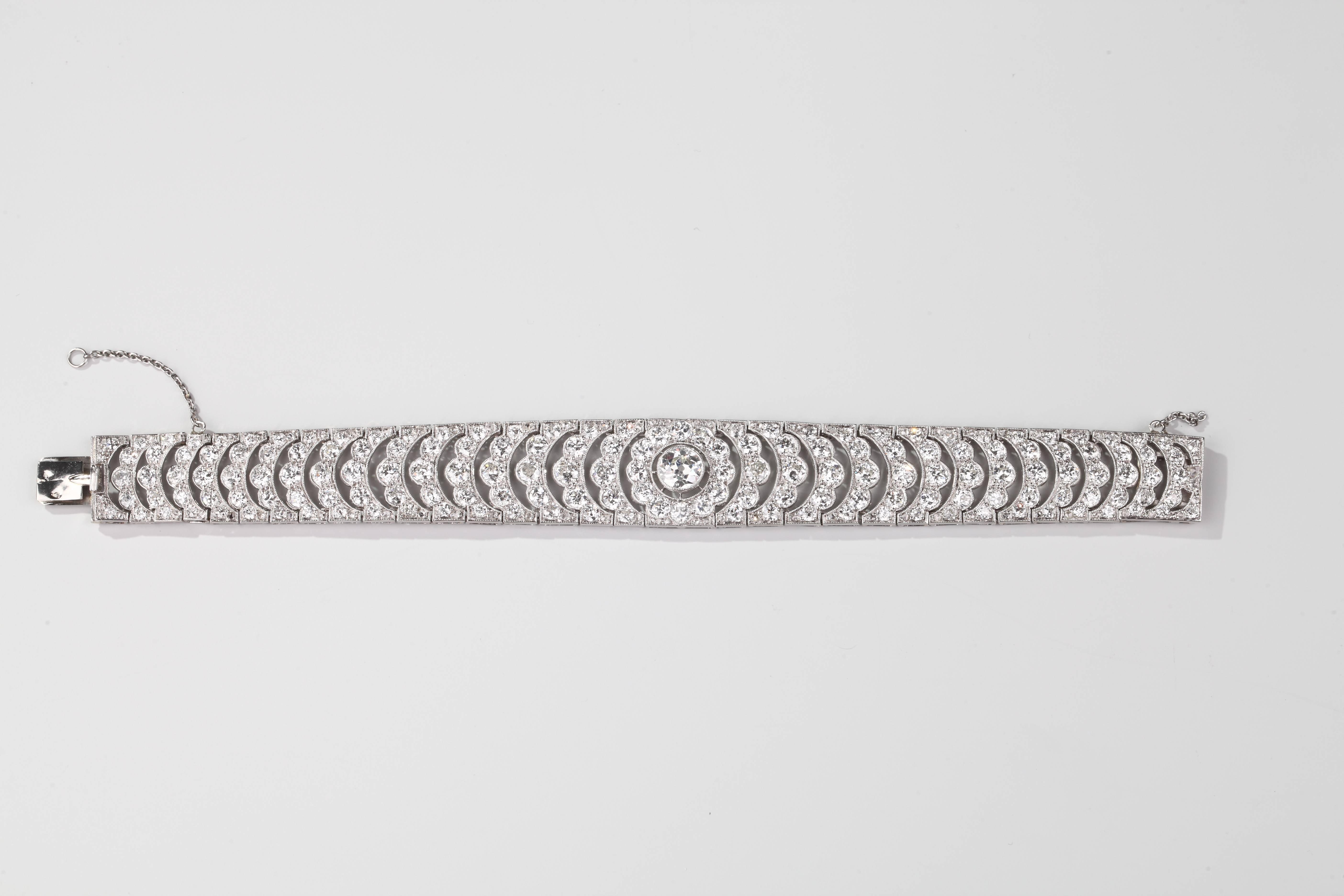 Formed of a smooth platinum and white gold ribbon articulated of arches decorated with old-cut diamonds, one more important in the center.
Extremely fine and smooth work.
French assay marks for platinum.
Circa 1925.
