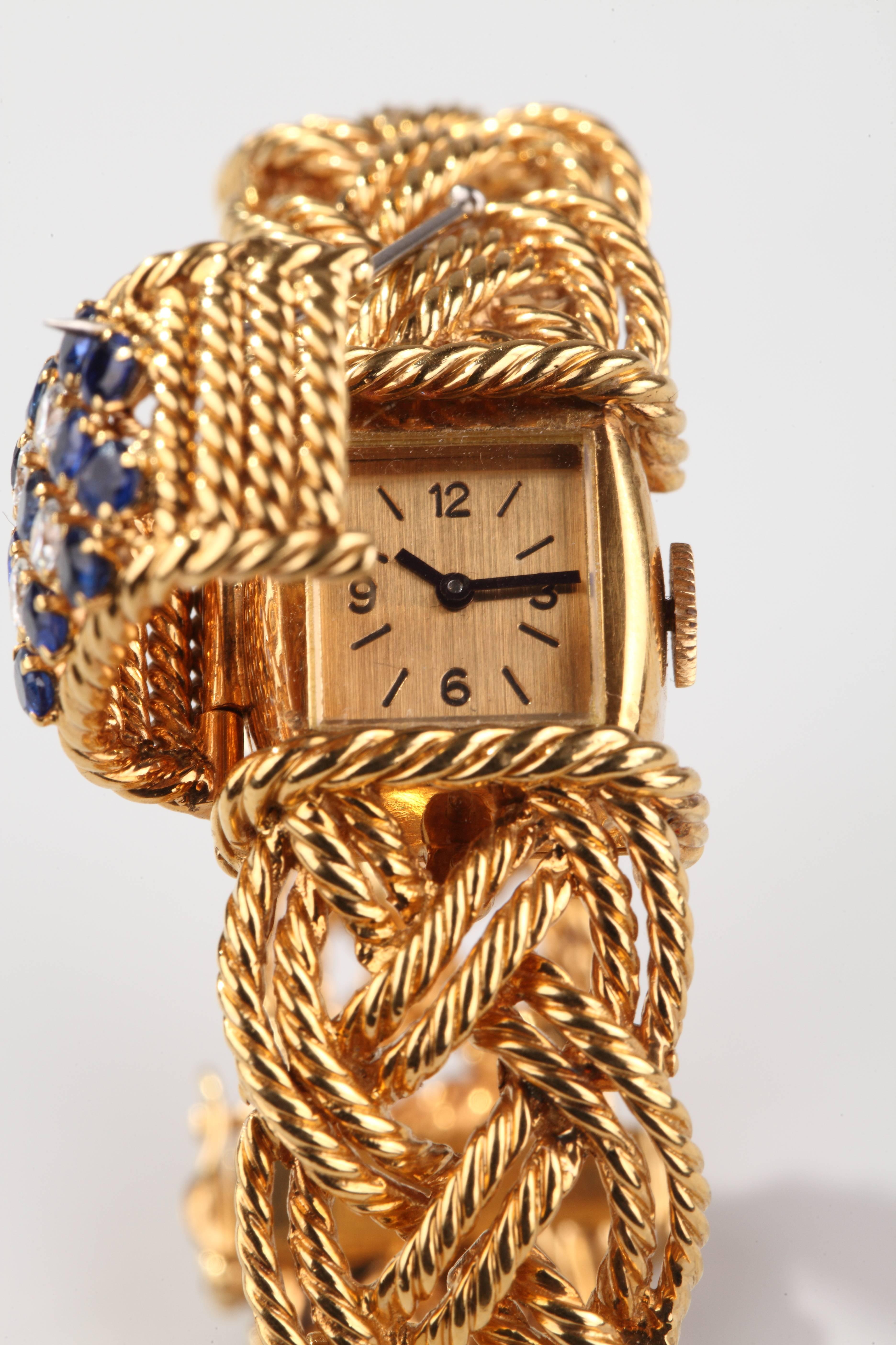 Boucheron Paris Formed of twisted yellow gold rope centered by a motif set with brillant cut diamonds and round blue sapphires, hiding a yellow gold watch.
Mechanical movement.
French assay marks for gold.
Signed and numbered .