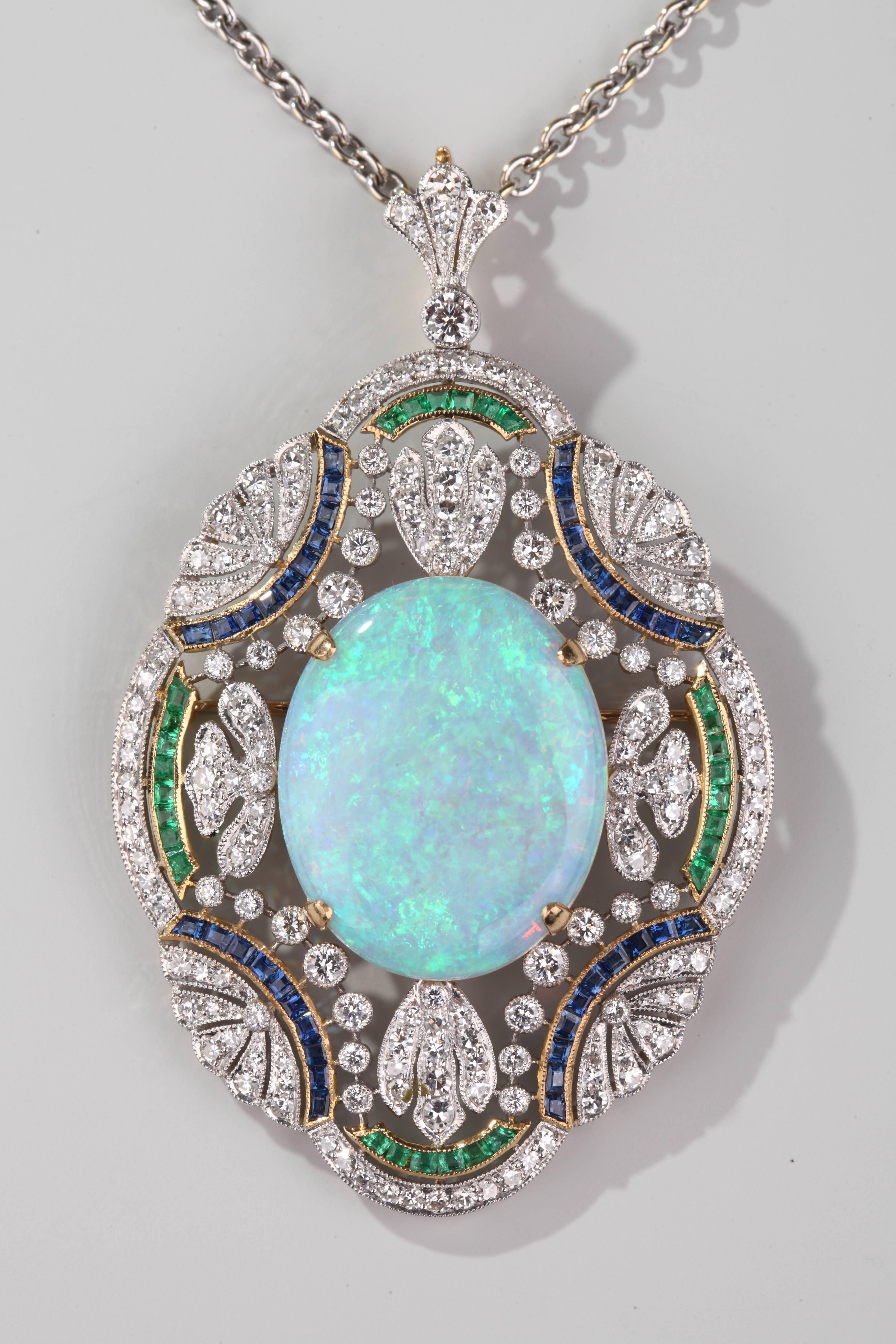 Very nice quadrilobate 18k gold (yellow and white) centered by an opal in a frame finely openwork set by 8/8 cut diamonds and calibrated sapphires and emeralds.

Can be worn as a brooch.
Accompanied by an 18k white gold chain.