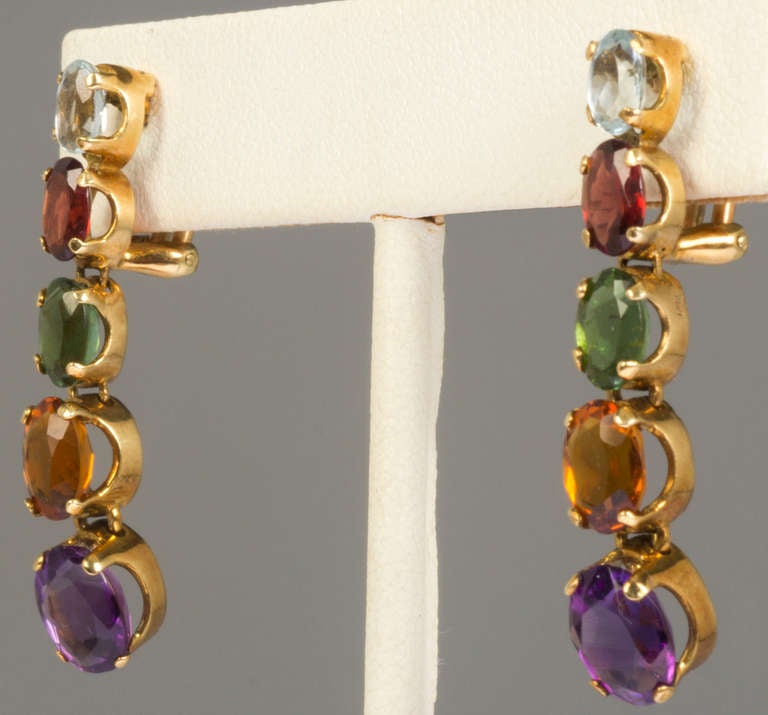These are beautiful earrings. Blue Topaz, garnet, savorite, citrine and amethyst  are mounted  in 18 karat gold and graduate in size. Marked 750 and signed JHR, they are pierced and have omega backs.