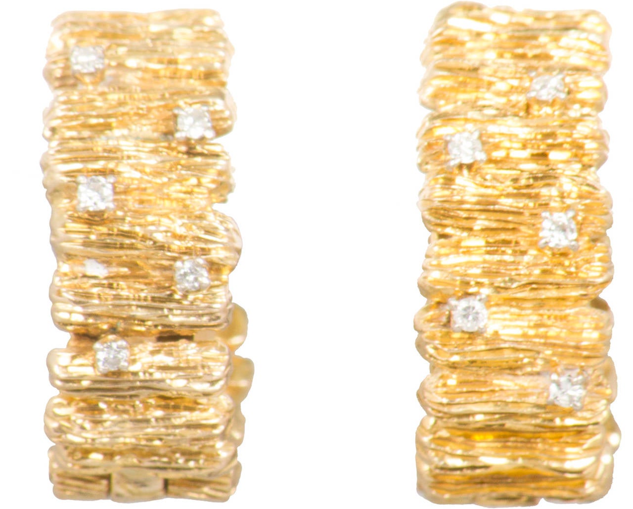 This is a pair of gold textured sculptural hoop earrings studded with diamonds.