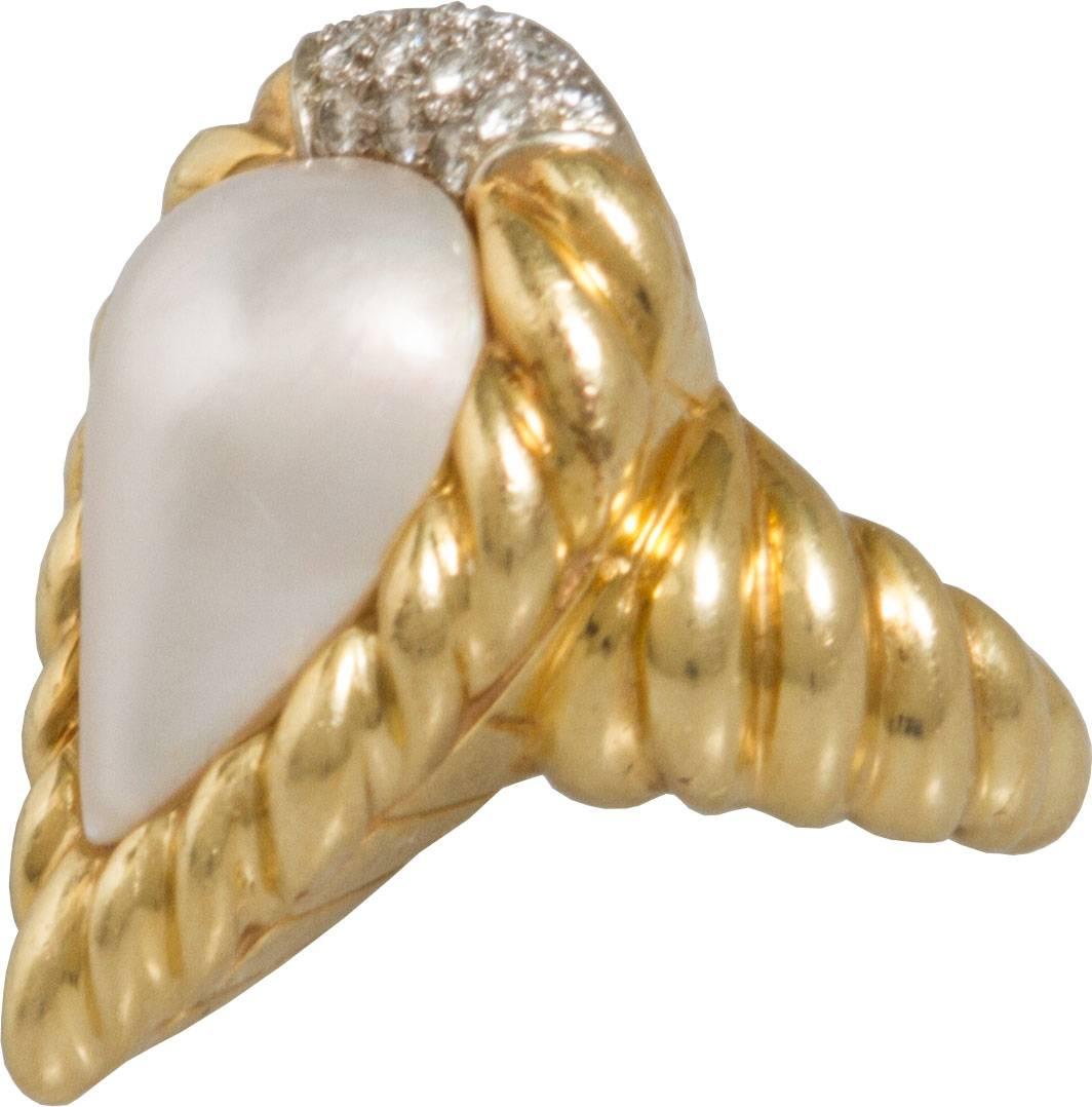 This large teardrop shaped lustrous mabe pearl ring pearl is set in a roped border accented with 12 pts of diamonds. 

The ring is a size 6