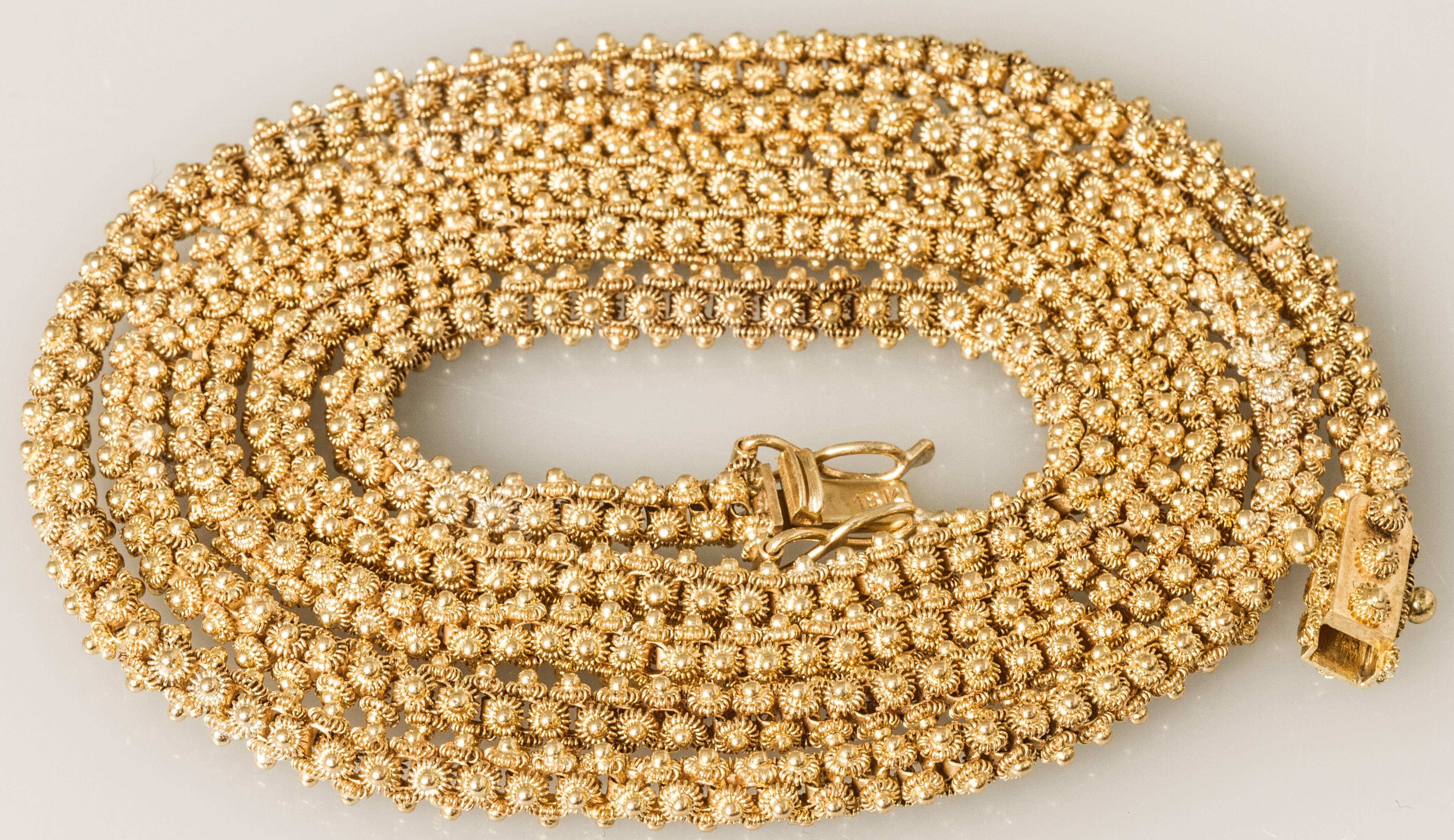 This necklace has a gorgeous link! The beautifully crafted links are adorned on four sides with stylized flower shaped granulated gold elements. It is thirty inches long and can be wrapped around the neck twice to form a gold choker.
There are two