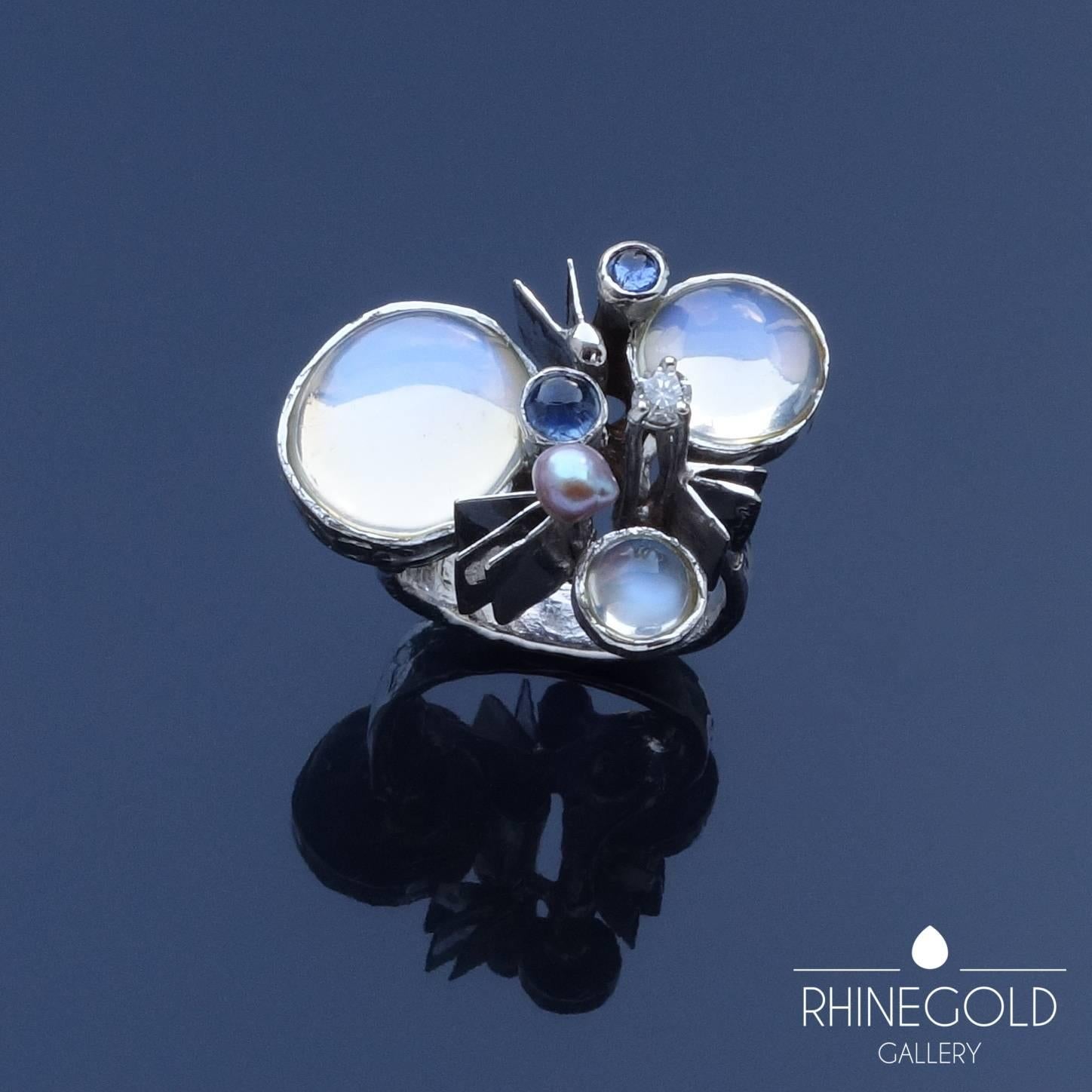 Klaus Neubauer: Modernist Sculptural Moonstone Sapphire Diamond Pearl White Gold Ring
14k white gold, moonstone, sapphire, brilliant cut diamond, oriental pearl
Ring head: 2.9 cm to 2.2 cm (approx. 1 1/8" to 7/8"); height 1.75 cm