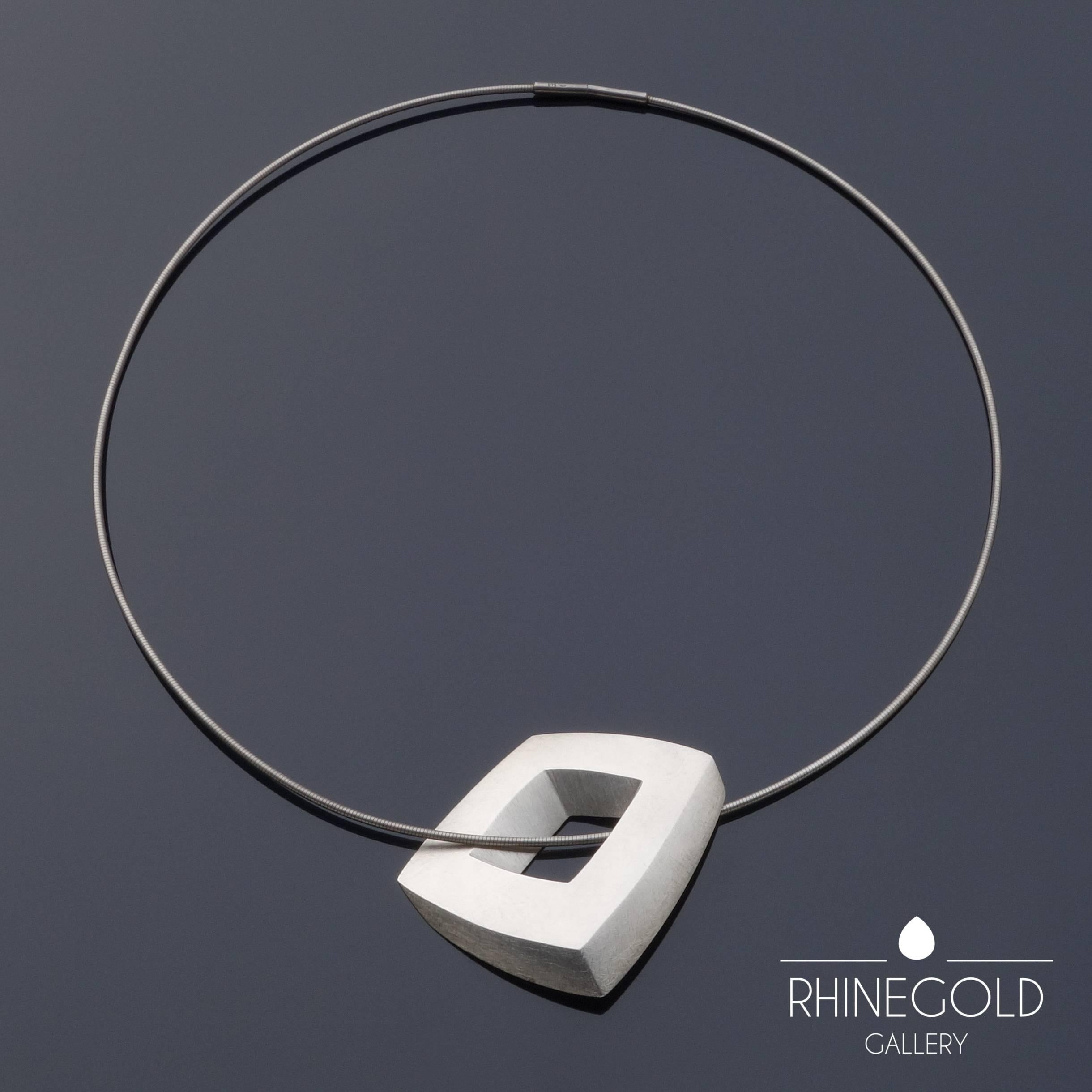 Claude Chavent: Illusionistic Cube Silver Pendant Necklace 
Sterling silver (pendant and neck ring)
Pendant 4.4 to 3.9 cm (approx. 1 3/4" to 1 9/16"), measured diagonal 5.4 cm (approx. 2 1/8"); circumference of neck ring 50 cm