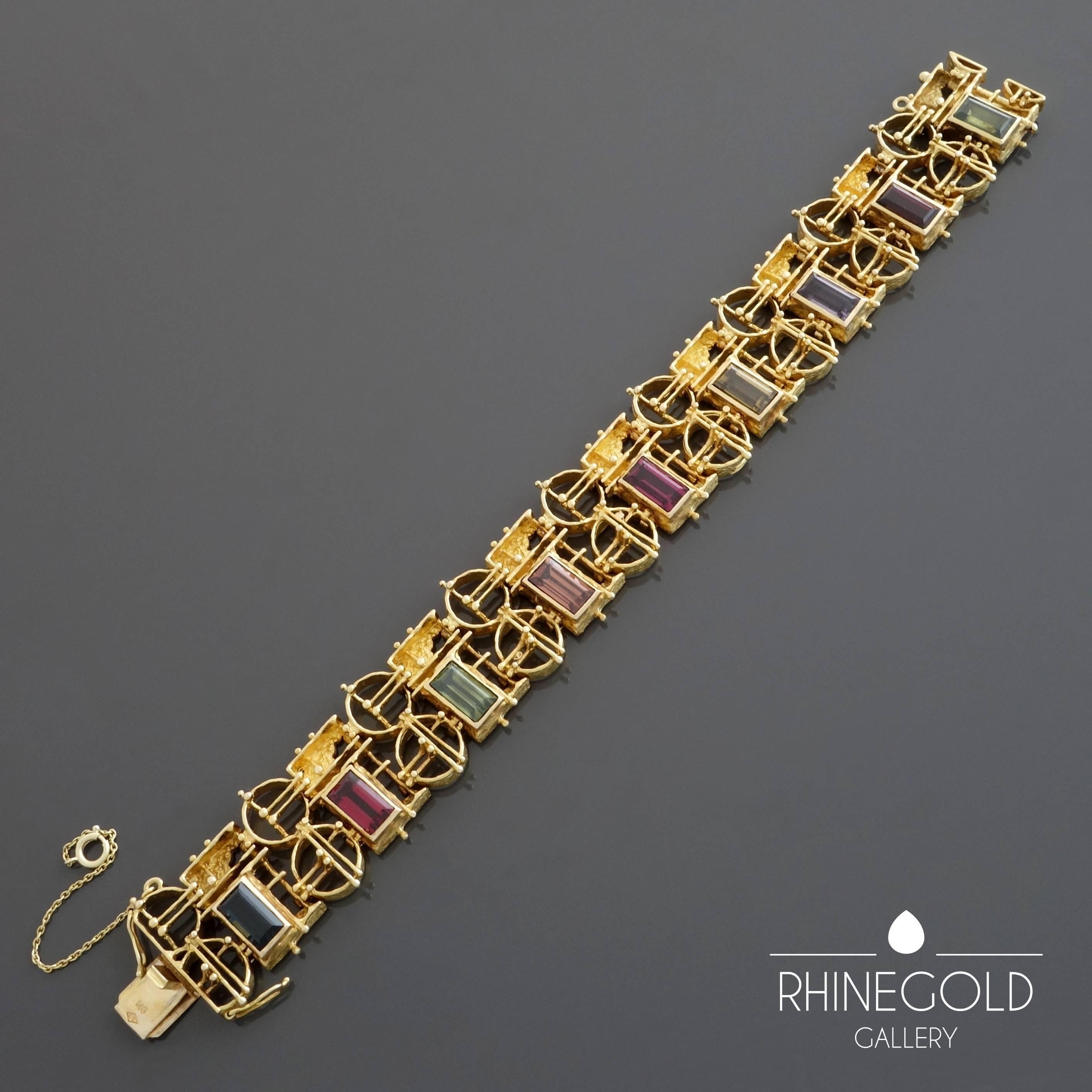 A 1960s 1970s modernist gold bracelet set with an array of autumn coloured garnet varieties, solidly worked (weighing approx. 65 grams) though delicate in appearance due to the detailed openwork of the links forming a flexible, well fitting,