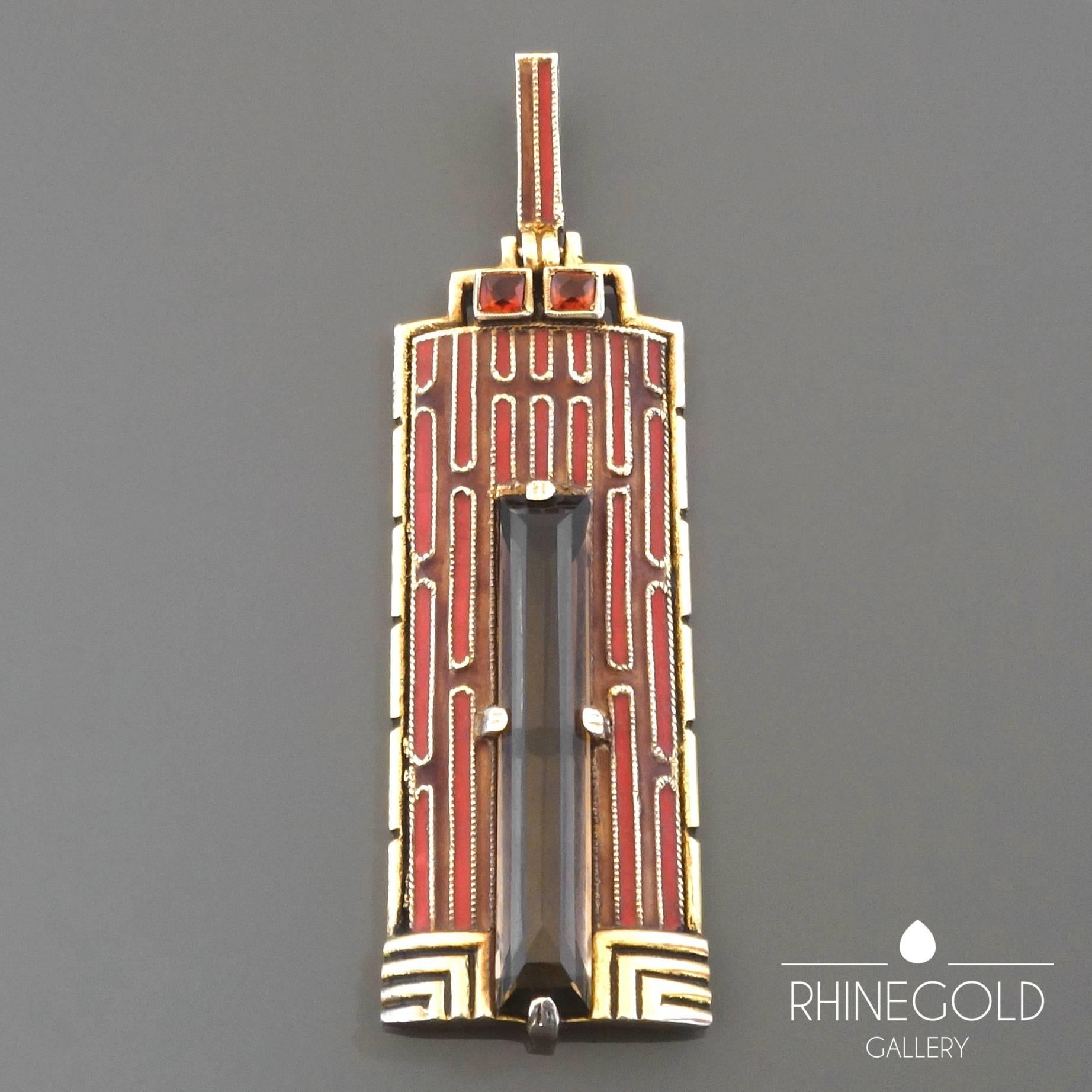 1920s Theodor Fahrner Art Deco Large Enamel Smoky Quartz Citrine Gilt Silver Pendant
Gilt silver, smoky quarz (approx. 7.5 to 8 carats), 2 citrines, matte enamel in red and cinnamon brown
Height 7.0 cm (approx. 2 3/4"), width 2.1 cm (approx.