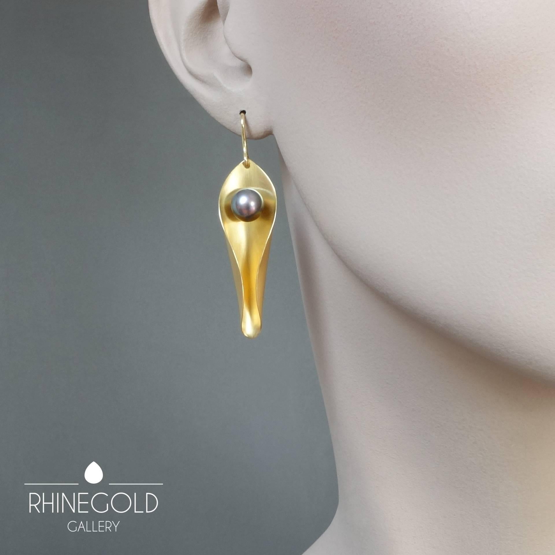 An Elegant Pair of Unique Modern Day-to-Night Pearl Gold Earrings
18k yellow gold, 2 grey cultured pearls
Length (incl.hook) approx. 2 3/16” (5.5 cm), width max. 9/16” (1.45 cm); diameter of pearls approx. 5/16” (8 mm)
Weight approx. 9.5
