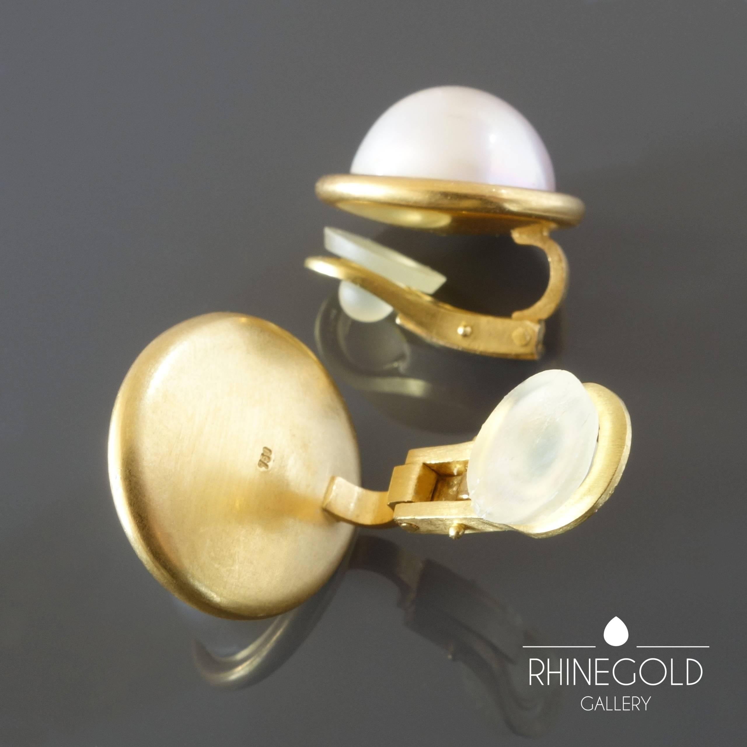 Modern Mabe Pearl Matte Gold Clip-on Earrings
18k yellow gold, mabe pearls
Diameter 1.9 cm (approx. 3/4“)
Weight approx. 19.1 grams
Marks: gold content mark ‘750’ for 18k gold
Germany, 1990s – 2000s 

A classical pair of mabe pearl earrings of a