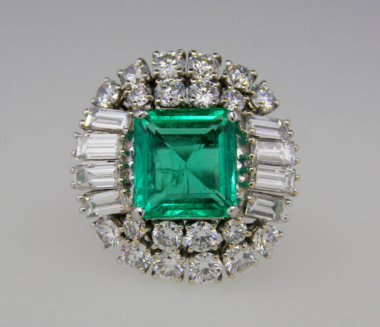 Ring set with a Colombian emerald weighing 5.59 carats, 8 baguette diamonds weighing 1.35 carats and 12 round diamonds weighing 2.39 carats. The emerald  has a Gubelin Gemstone Report dated November 2012 stating: minor clarity enhancement. 

Mounted