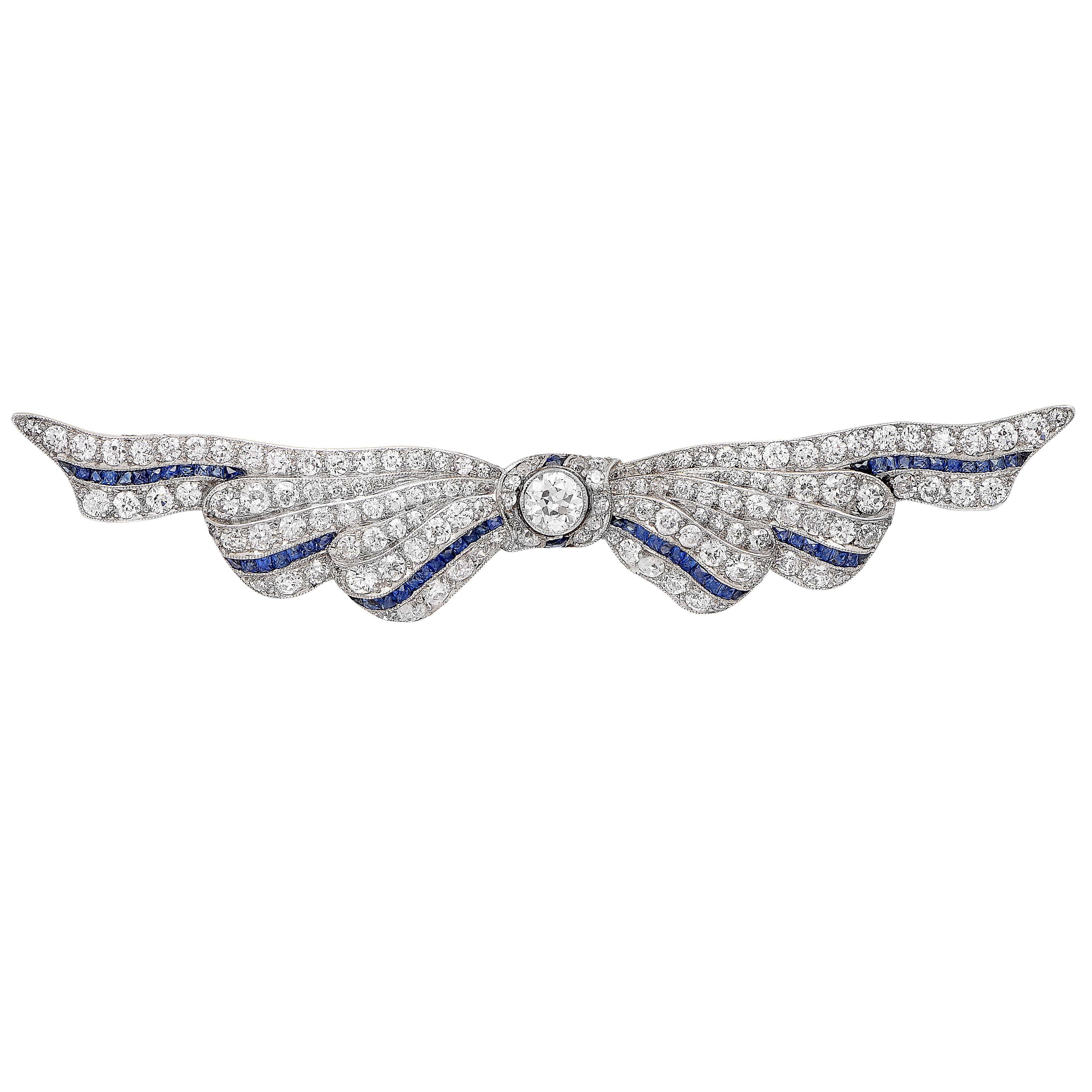 Diamond and Sapphire Ribbon Platinum Brooch featuring 126 mix cut diamonds with an approximate total weight of 3 carats. Circa 1930's

Metal Type: Platinum (stamped and/or tested)
Metal Weight: 9.6 Grams