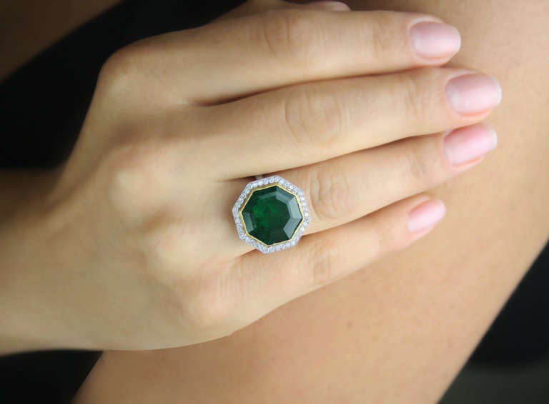 Platinum ring set with an octagonal-shaped emerald weighing approximately 8.50 carats, further set with round diamonds. Very fine millegrain workmanship. 
Size 5 1/2.
Can be sized at no charge.