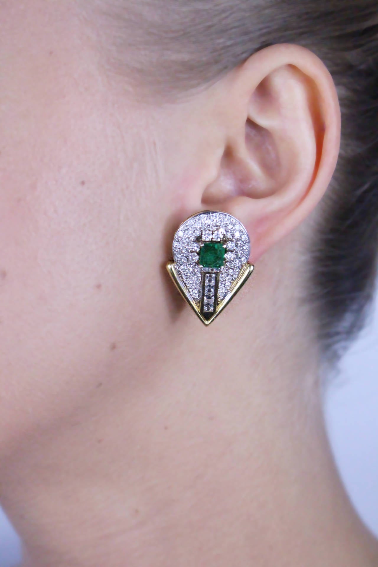 Natural Emerald and diamond earrings set with 124 round and square diamonds weighing approximately 2.80 carats, and 2 square cut natural emeralds. 

Metal Type: 18Kt Yellow Gold
Metal Weight: 24 Grams